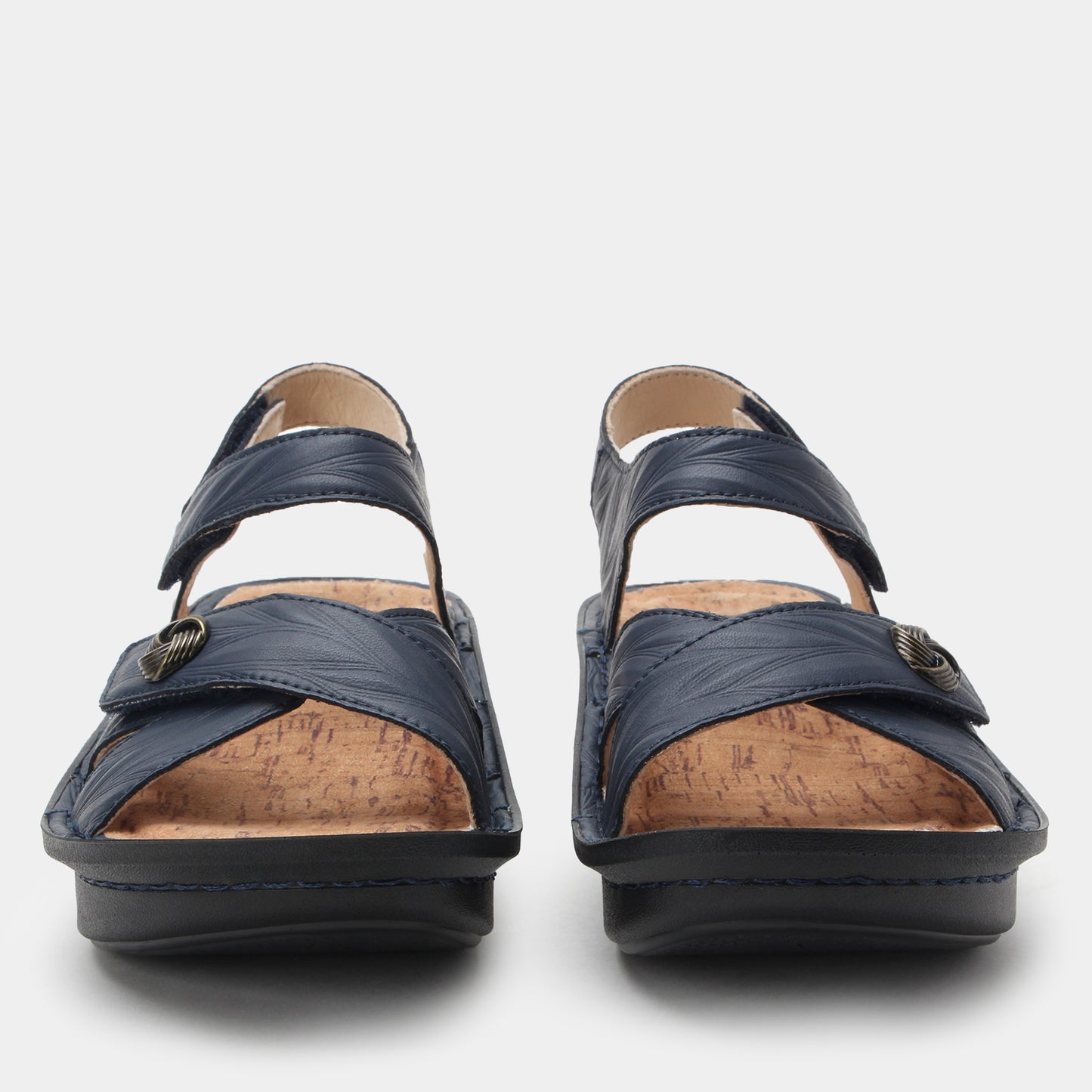 Pair of navy sandals with cork insoles on a light gray background