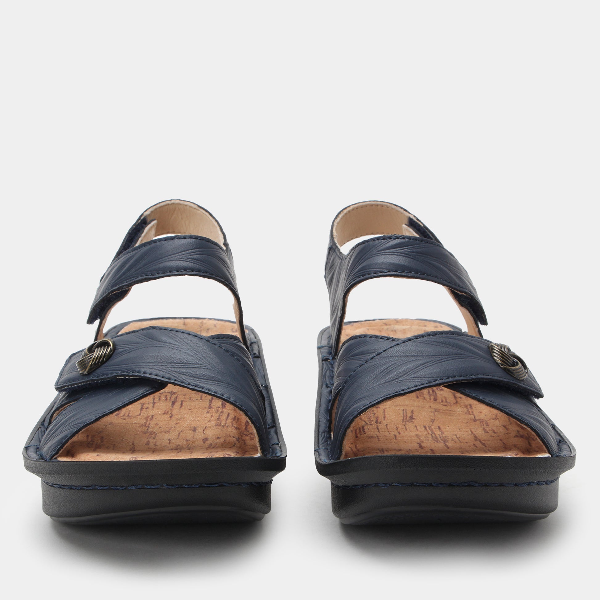 Pair of navy sandals with cork insoles on a light gray background