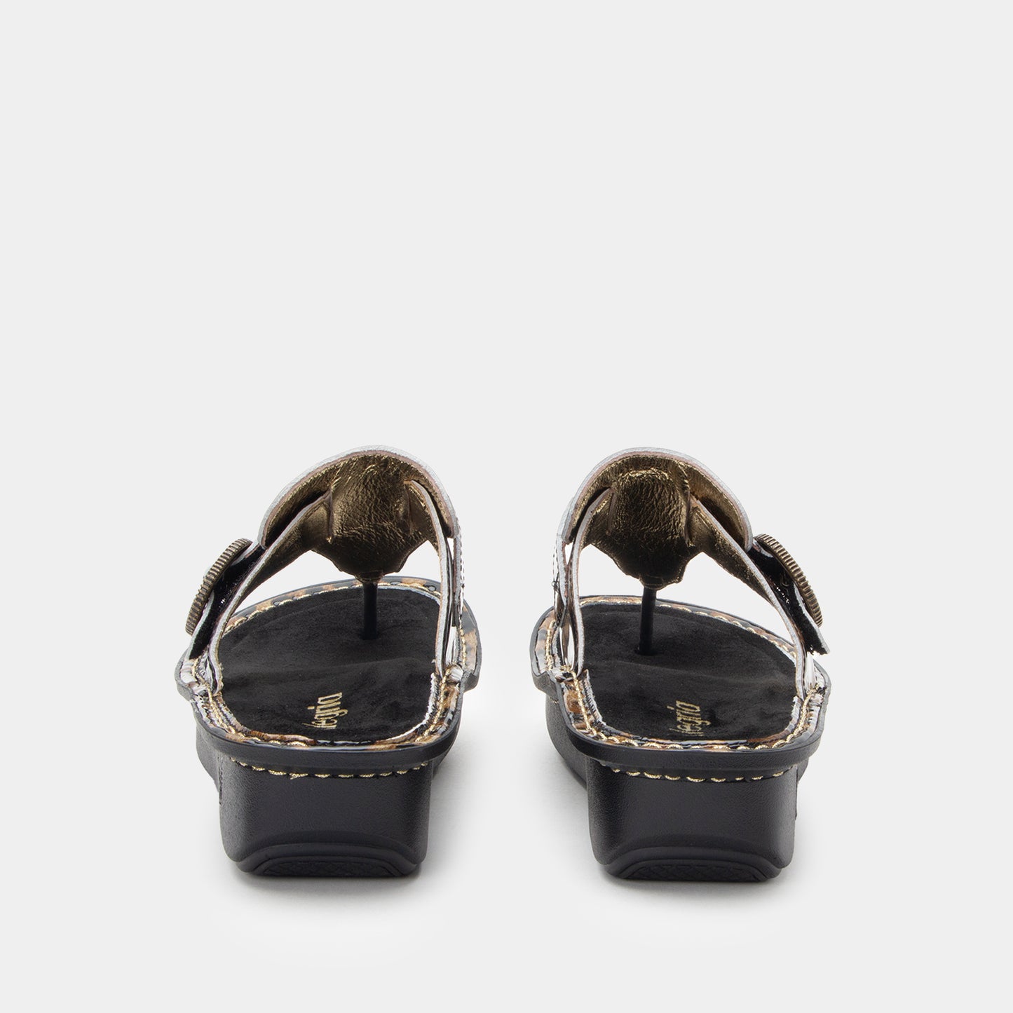 Black sandals with gold accents on a white background