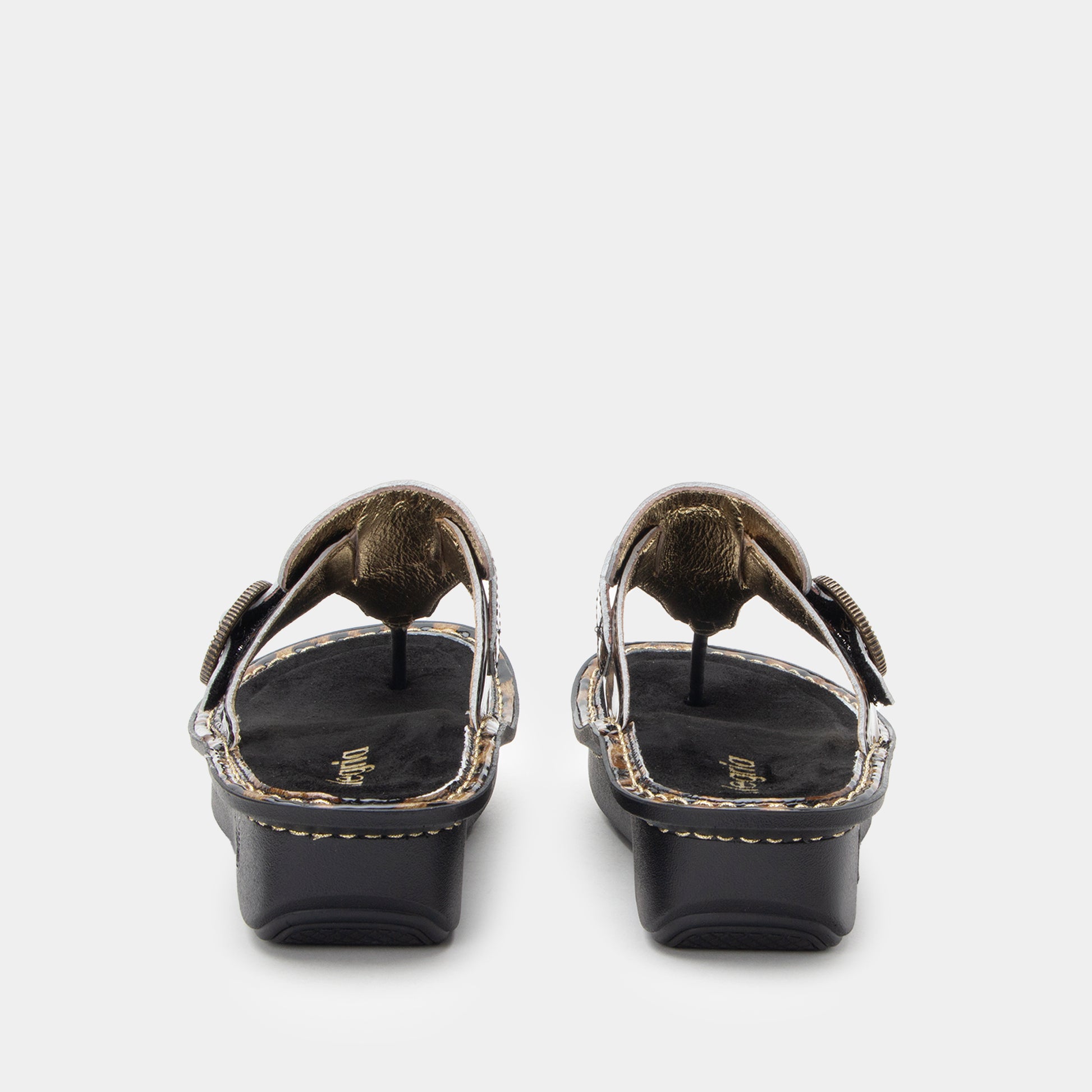 Black sandals with gold accents on a white background