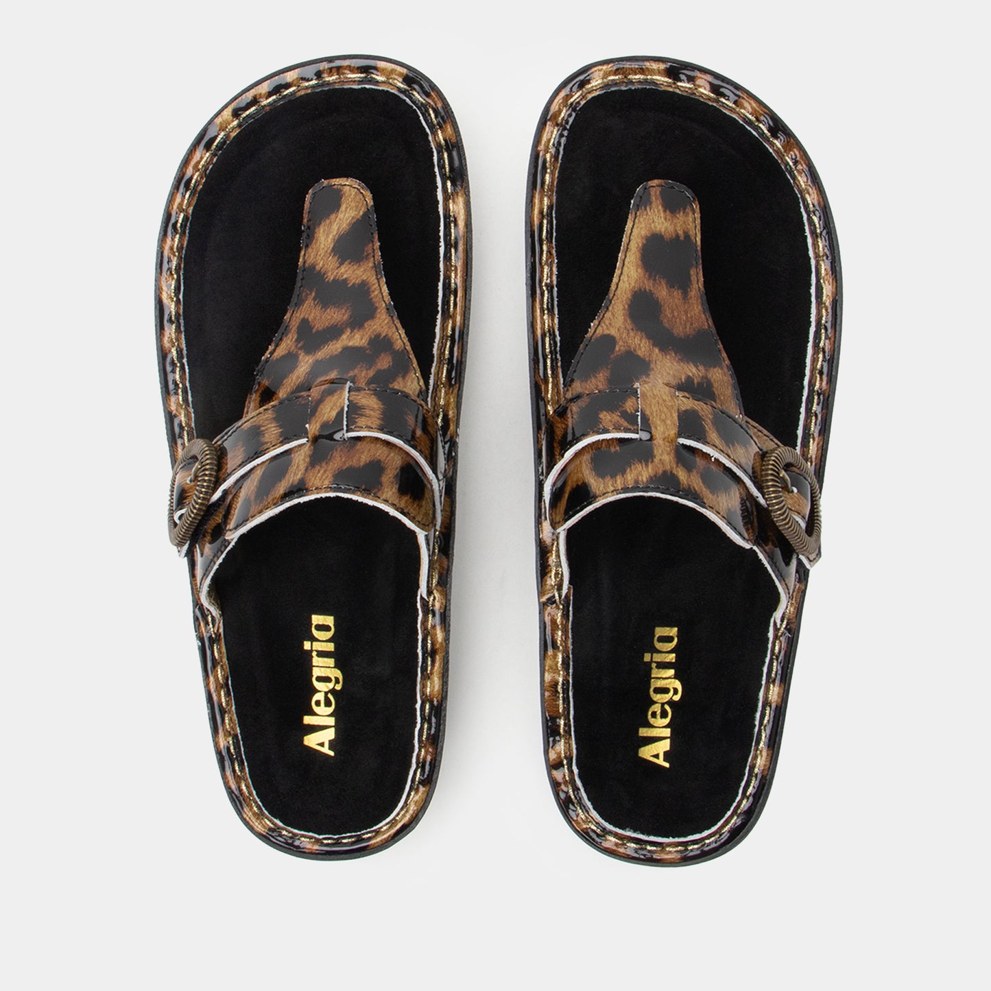 Pair of leopard print sandals with 'Alegria' branding on a light gray background