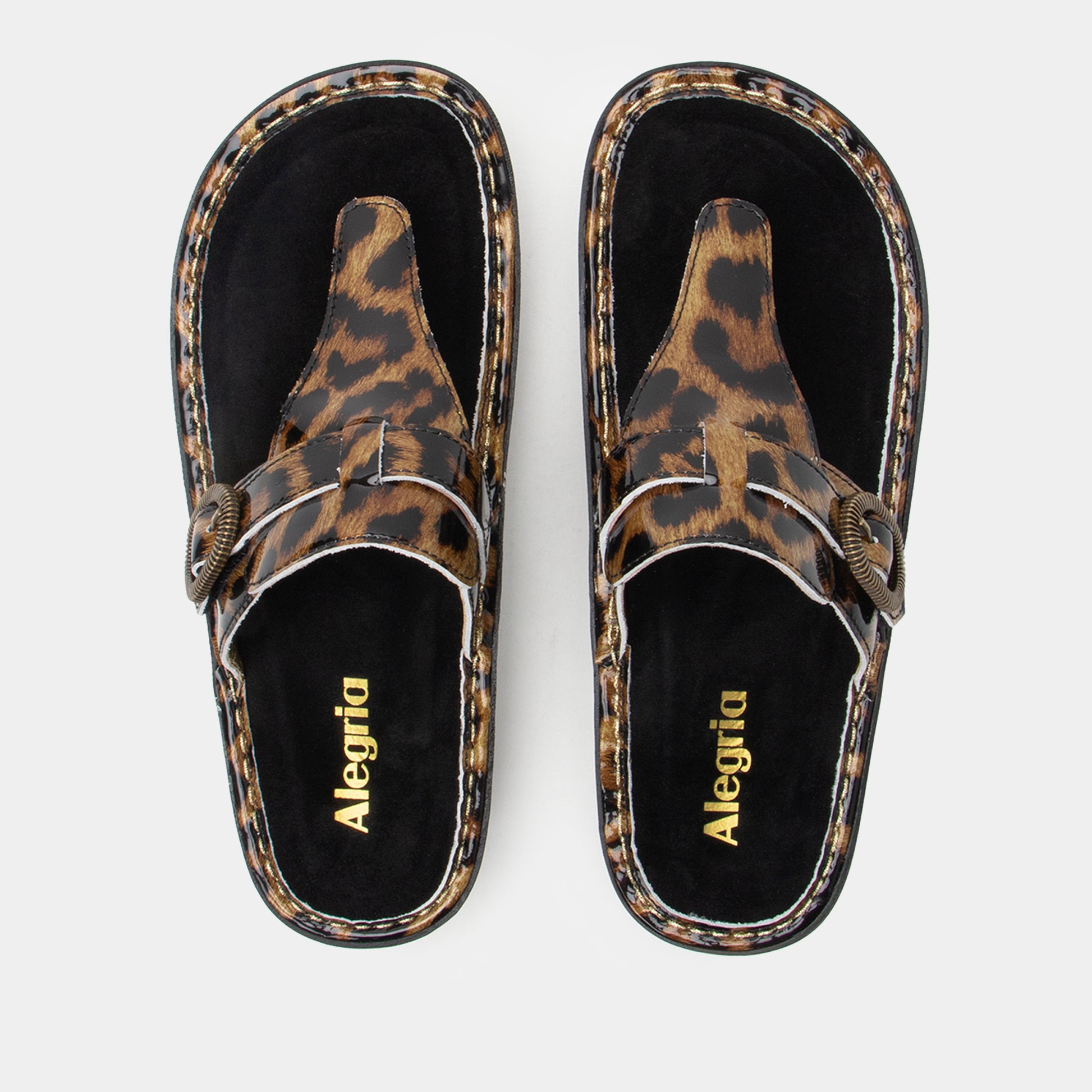 Pair of leopard print sandals with 'Alegria' branding on a light gray background