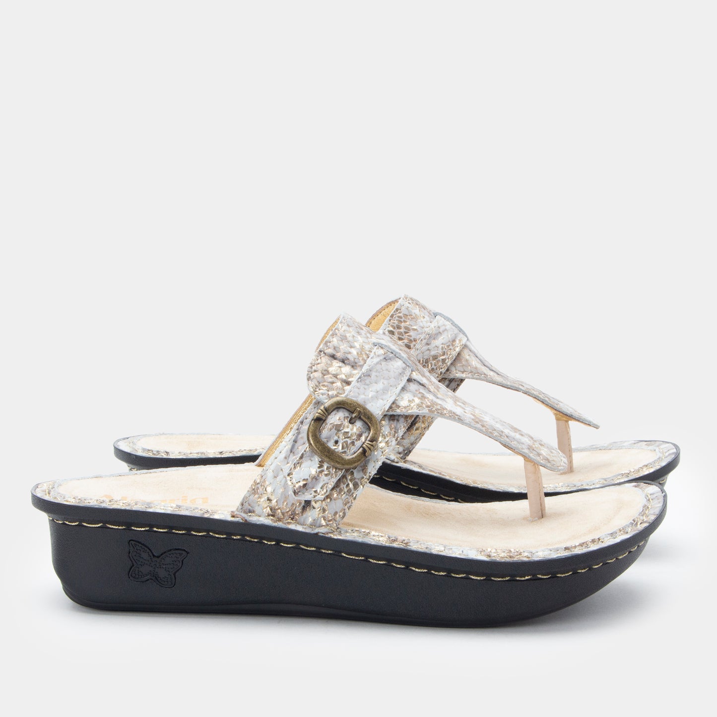 Silver sandal with decorative strap on a white background