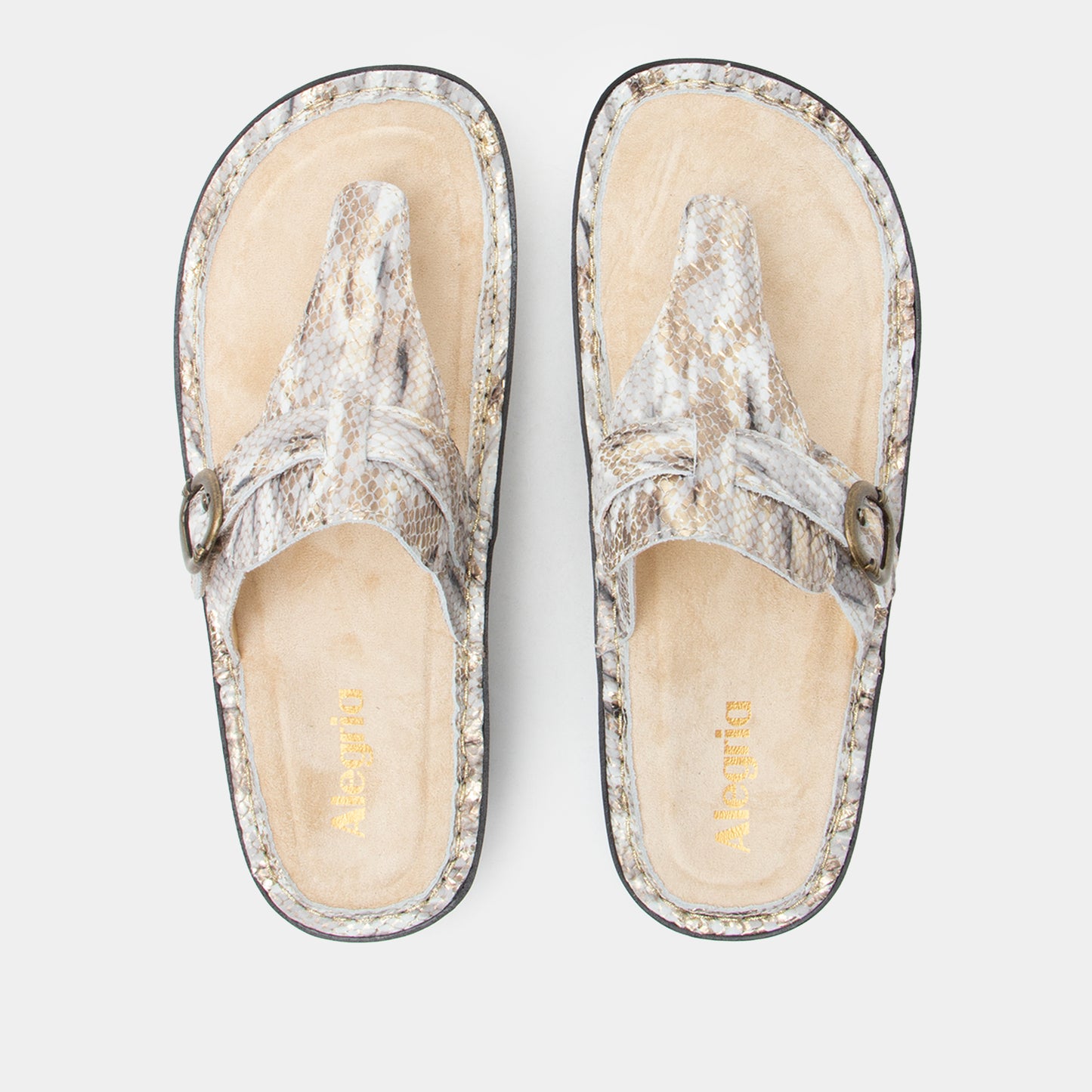 Pair of silver glittery sandals on a light gray background