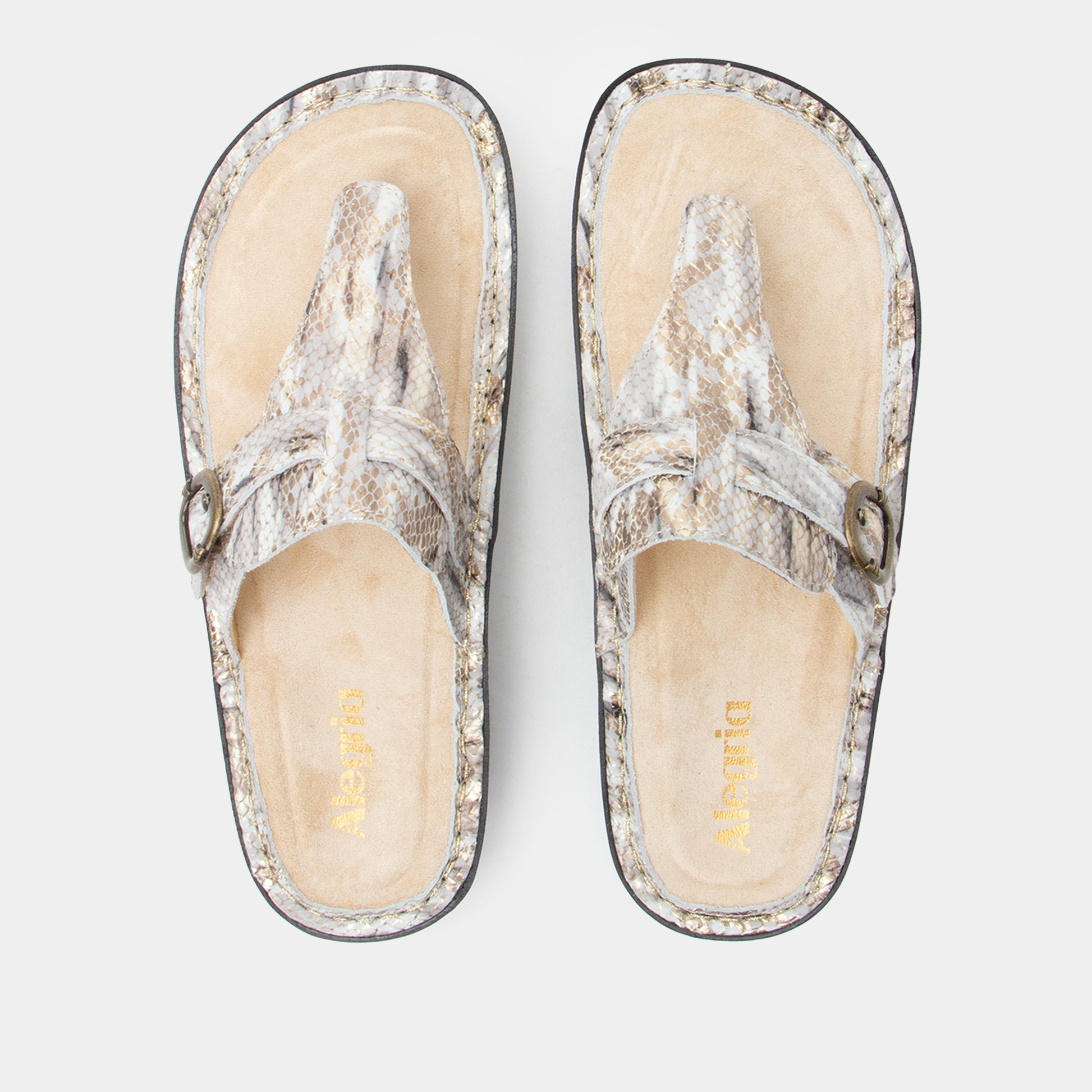 Pair of silver glittery sandals on a light gray background