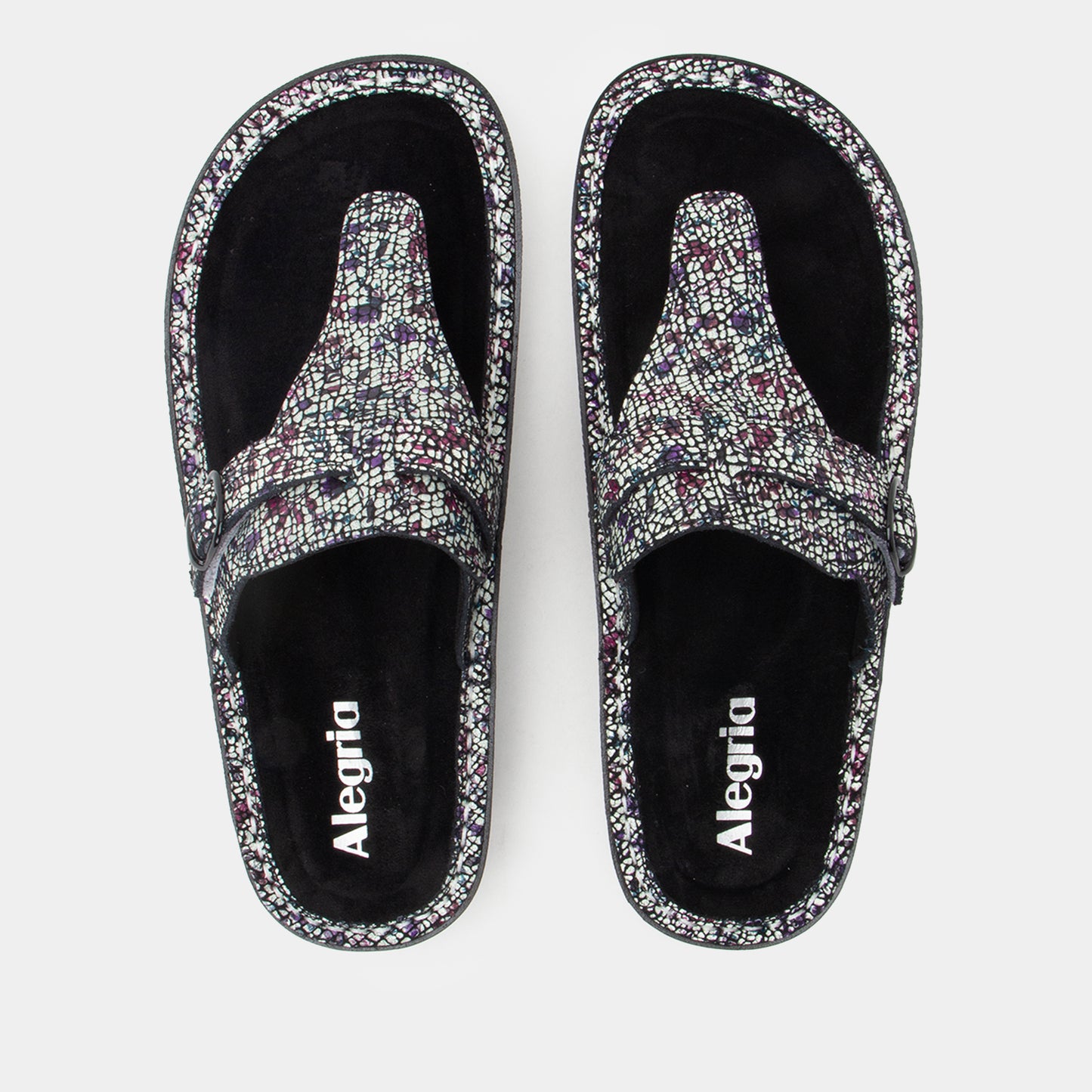 Pair of Alegria sandals with floral pattern on a white background