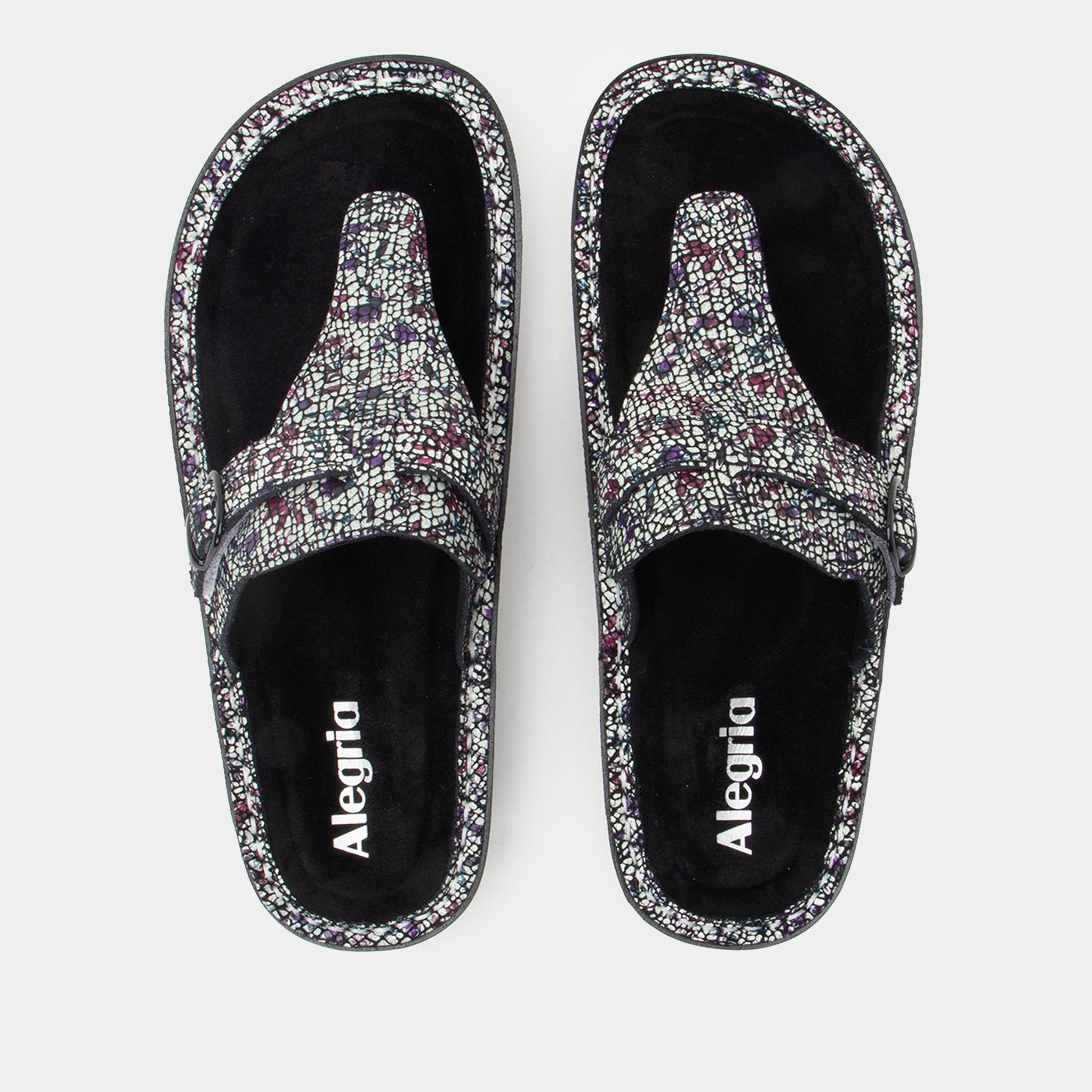 Pair of Alegria sandals with floral pattern on a white background