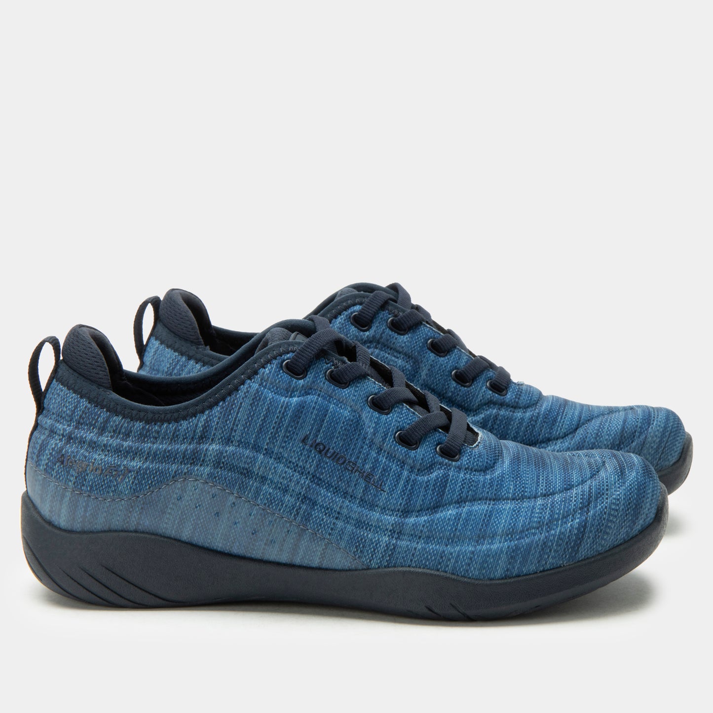 Blue sneakers with black soles on a light gray background