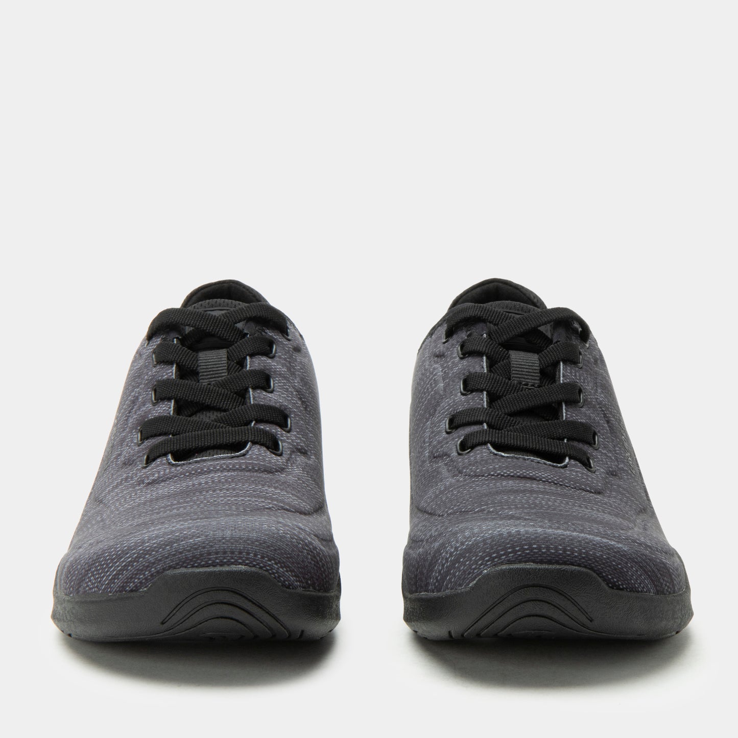 Pair of gray sneakers with black laces on a white background