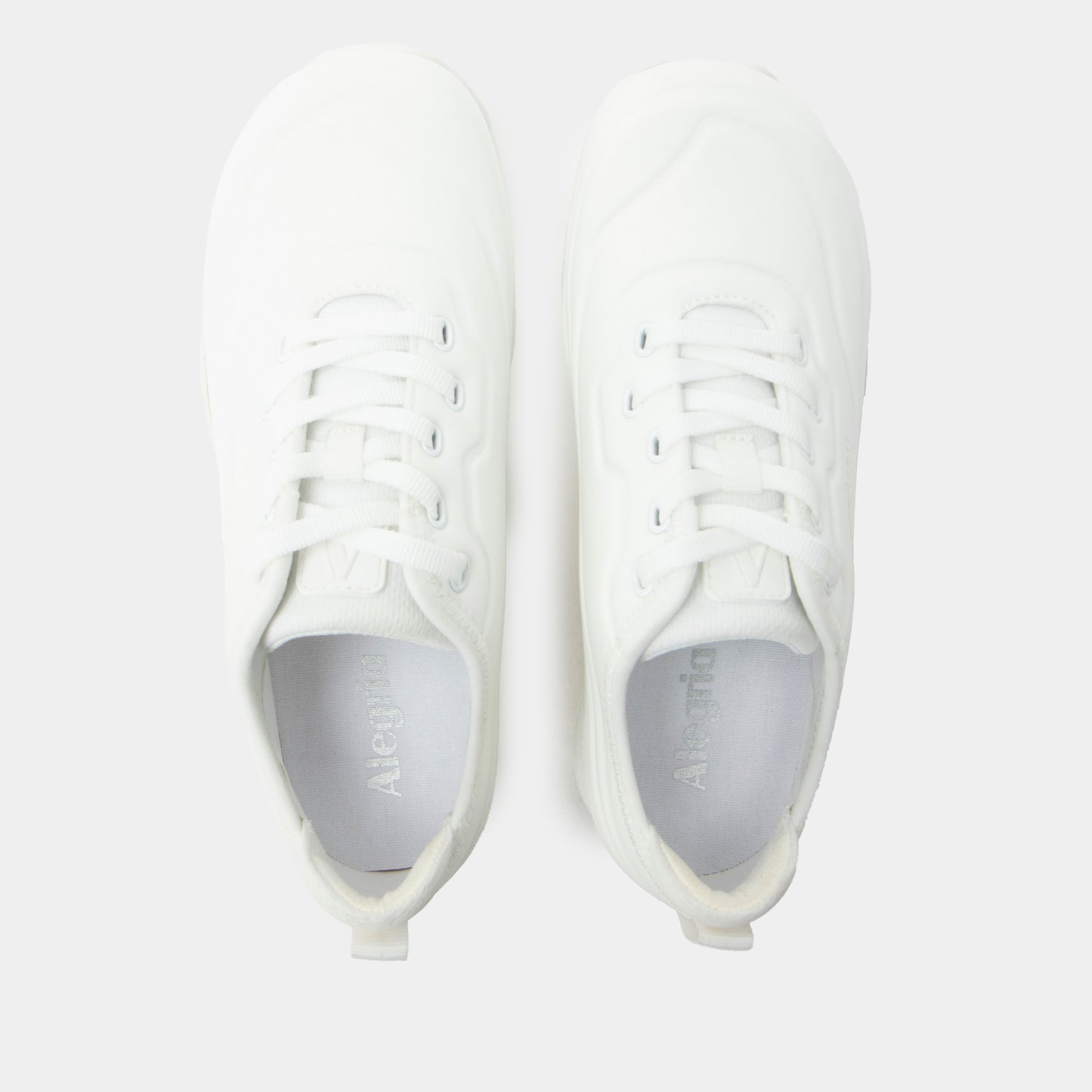 White sneakers with gray soles on a light gray background
