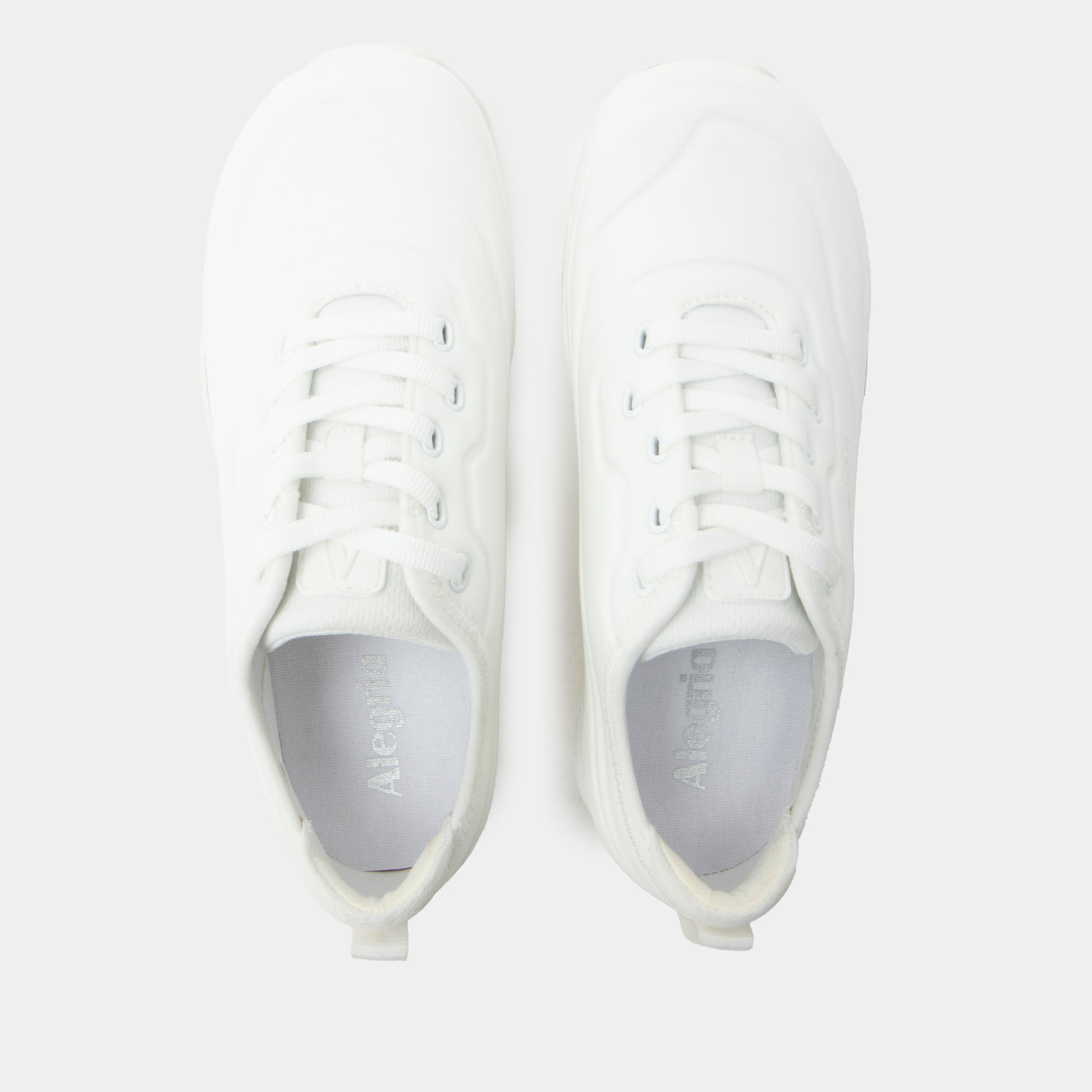 White sneakers with gray soles on a light gray background