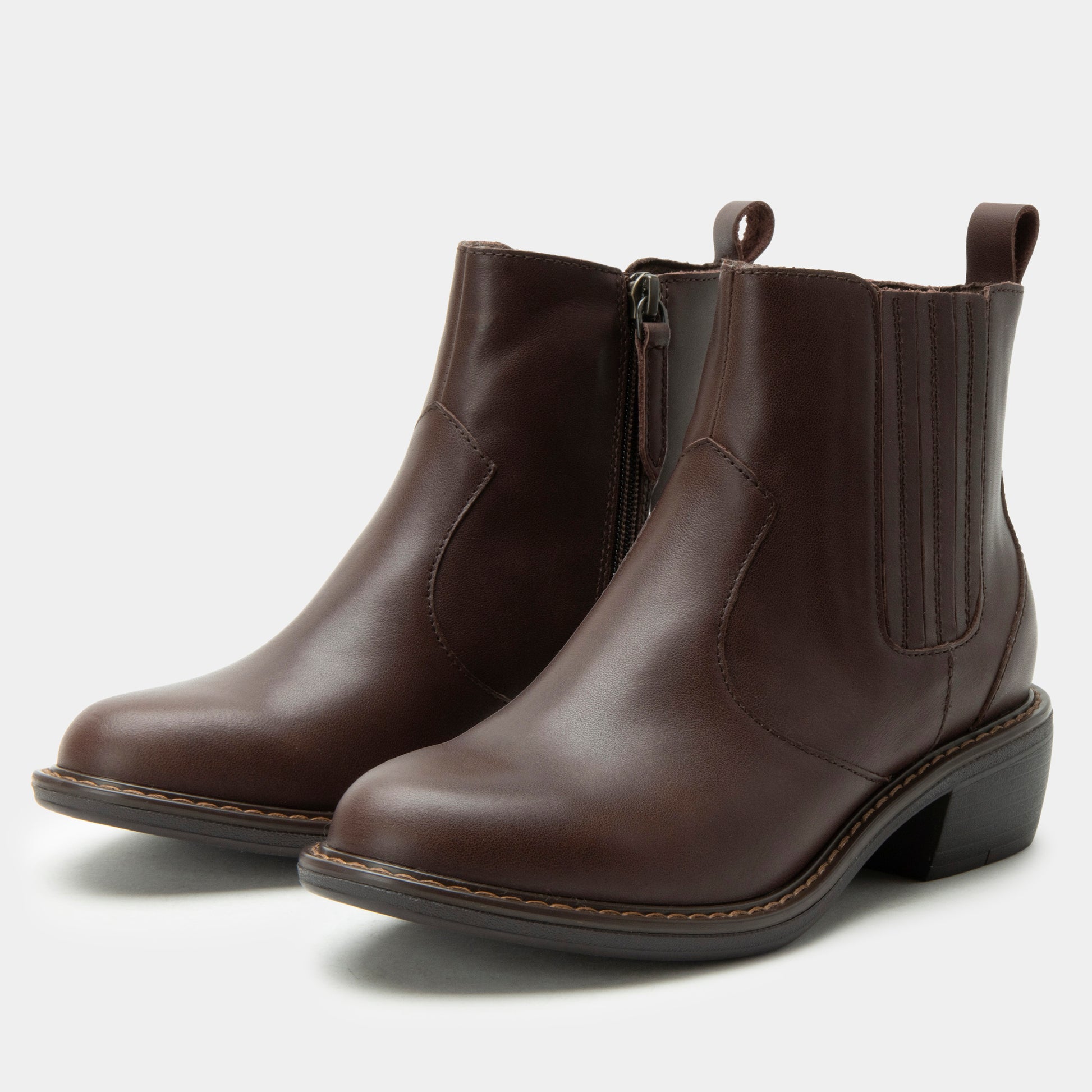 Pair of brown leather ankle boots on a light gray background