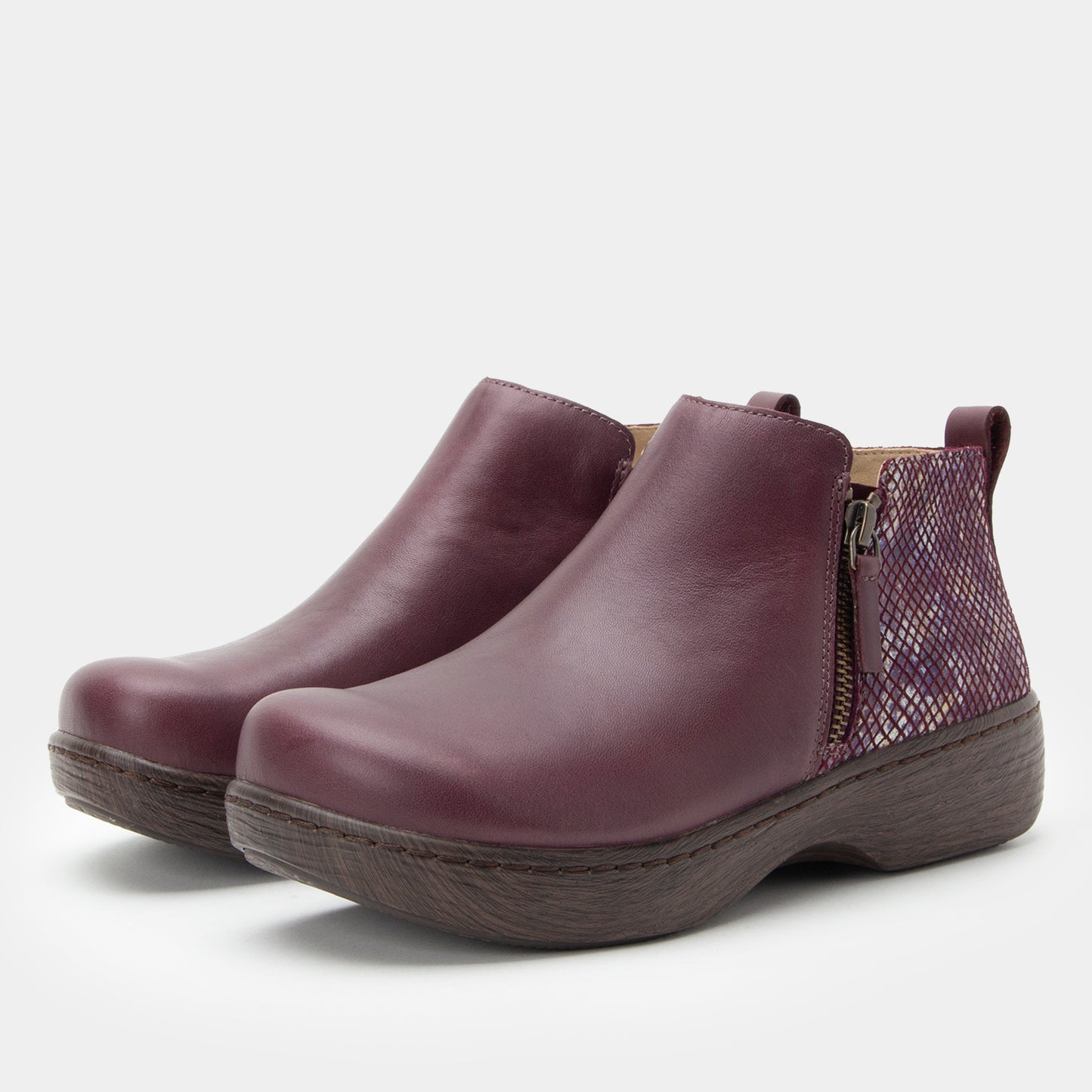 Pair of purple ankle boots with a snake print panel on a light gray background