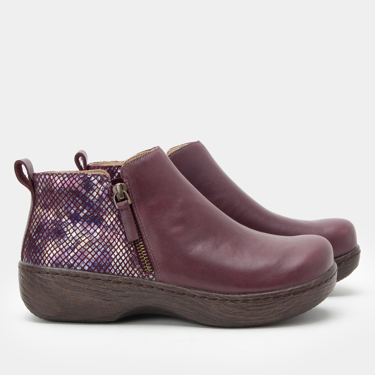 Pair of purple ankle boots with a patterned side panel on a light gray background