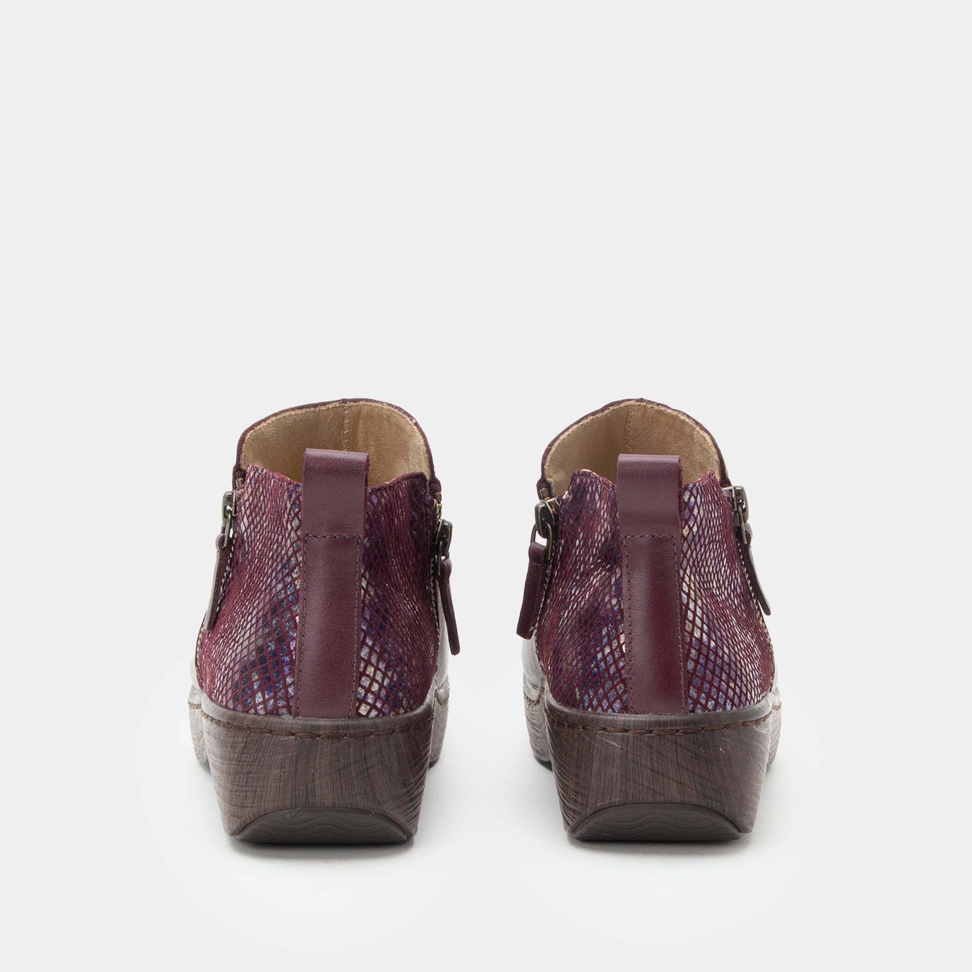 Pair of purple wedge shoes on a white background