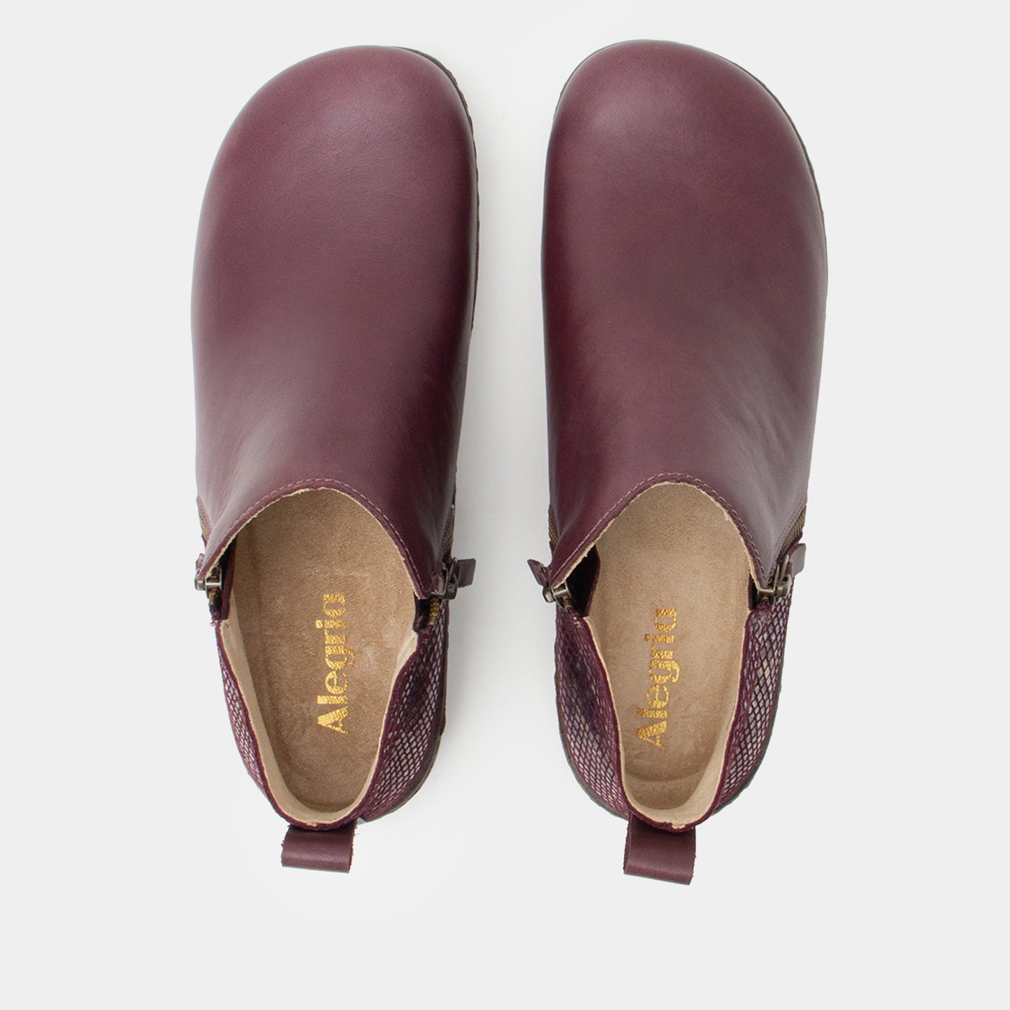 Pair of purple leather clogs on a white background