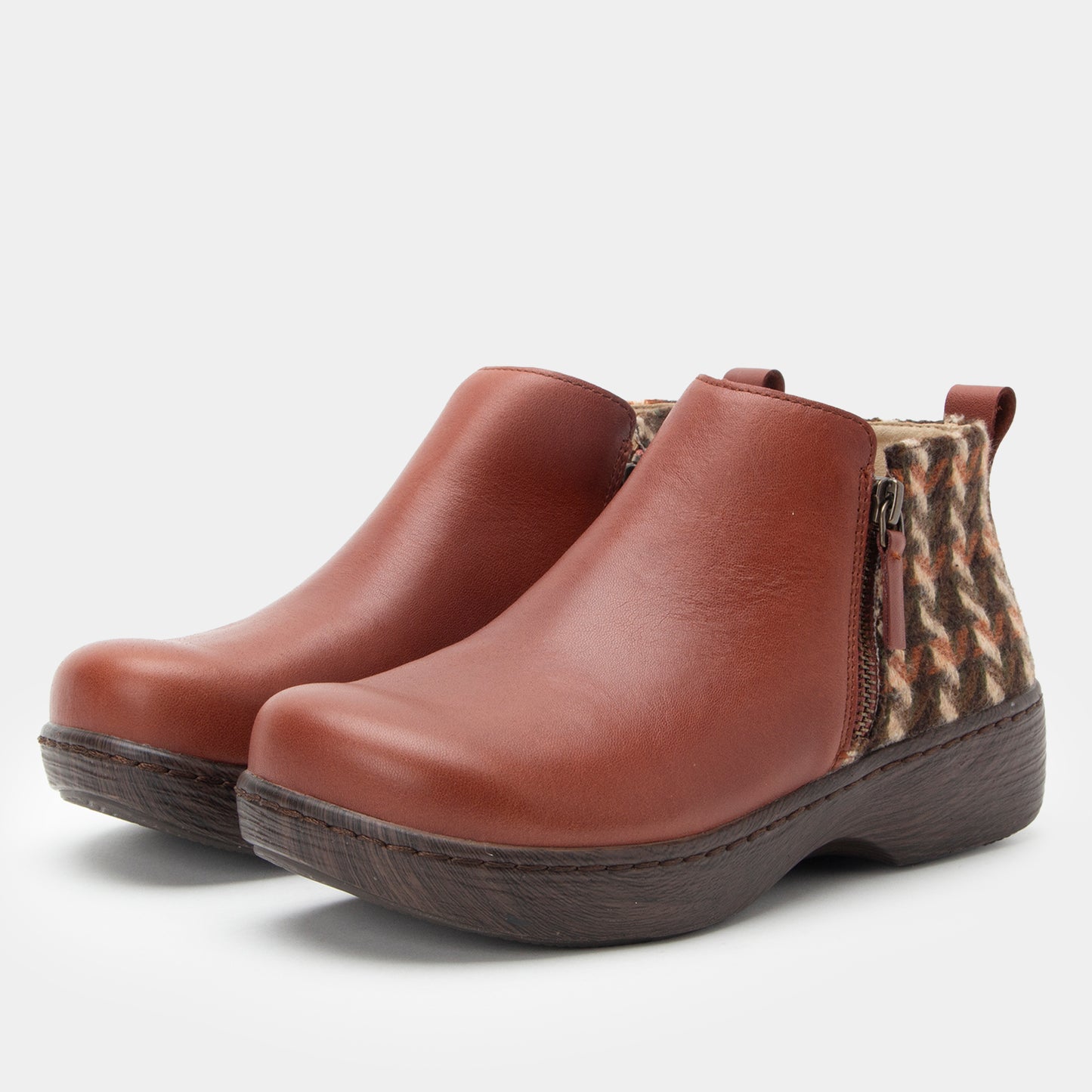 Brown ankle boots with leopard print zipper on a light gray background