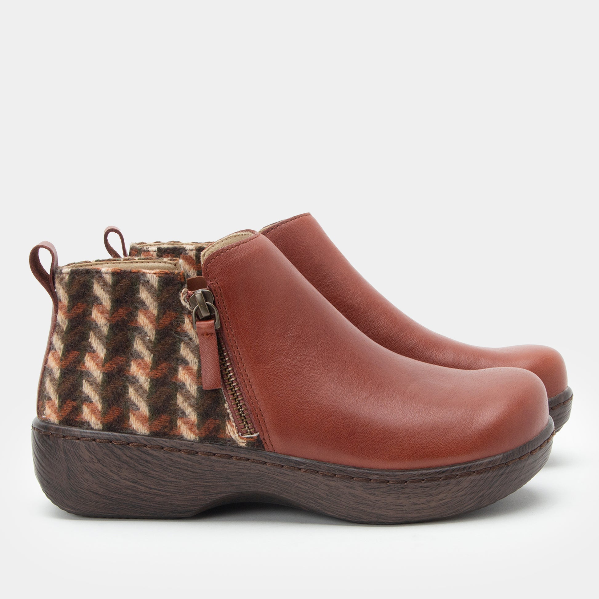 Brown ankle boots with patterned side panel on a light gray background