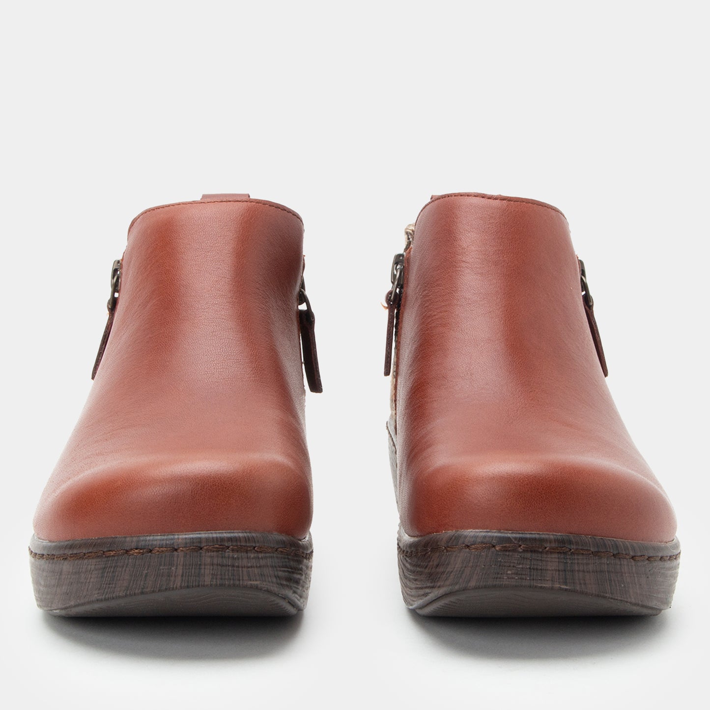 Pair of brown leather ankle boots on a white background