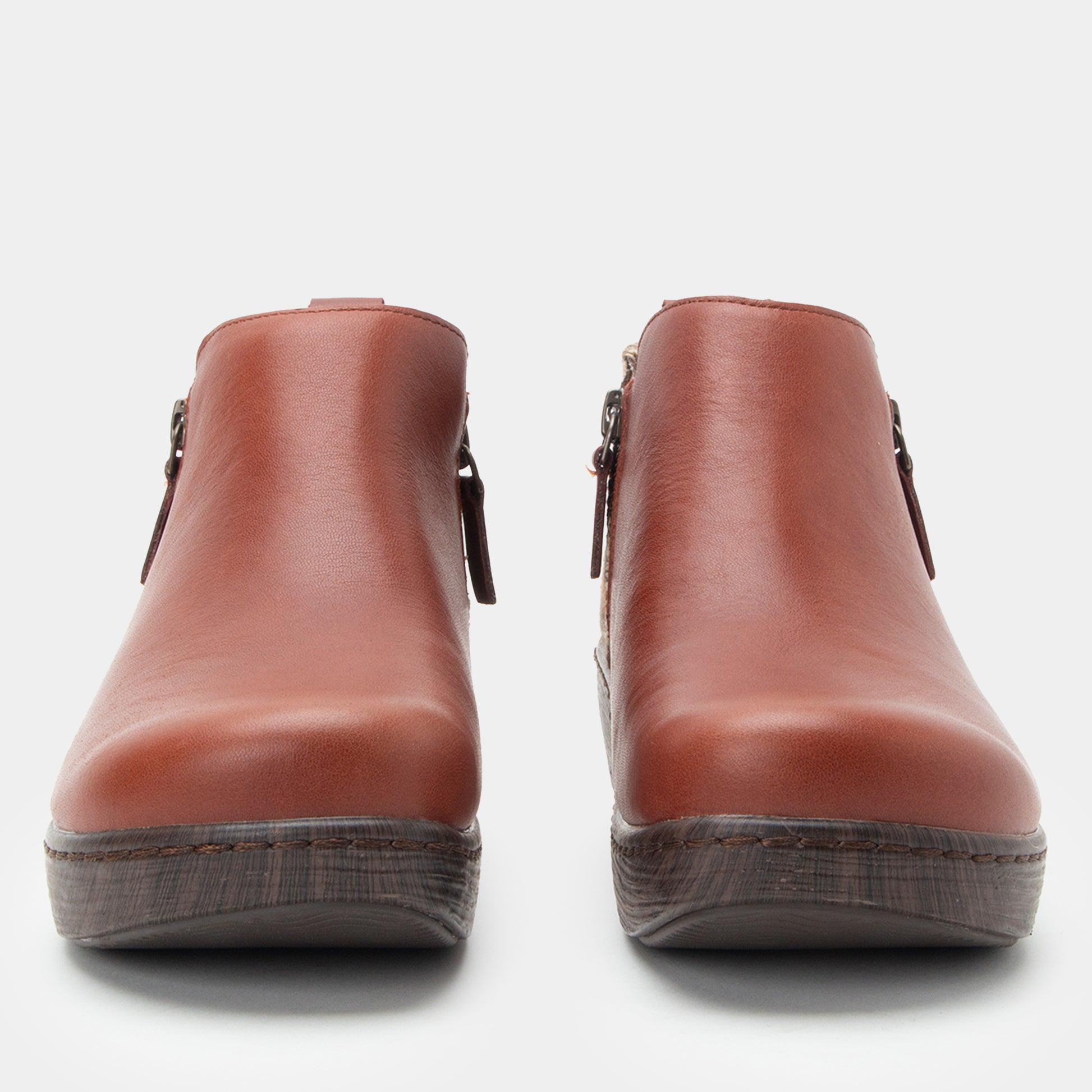 Pair of brown leather ankle boots on a white background