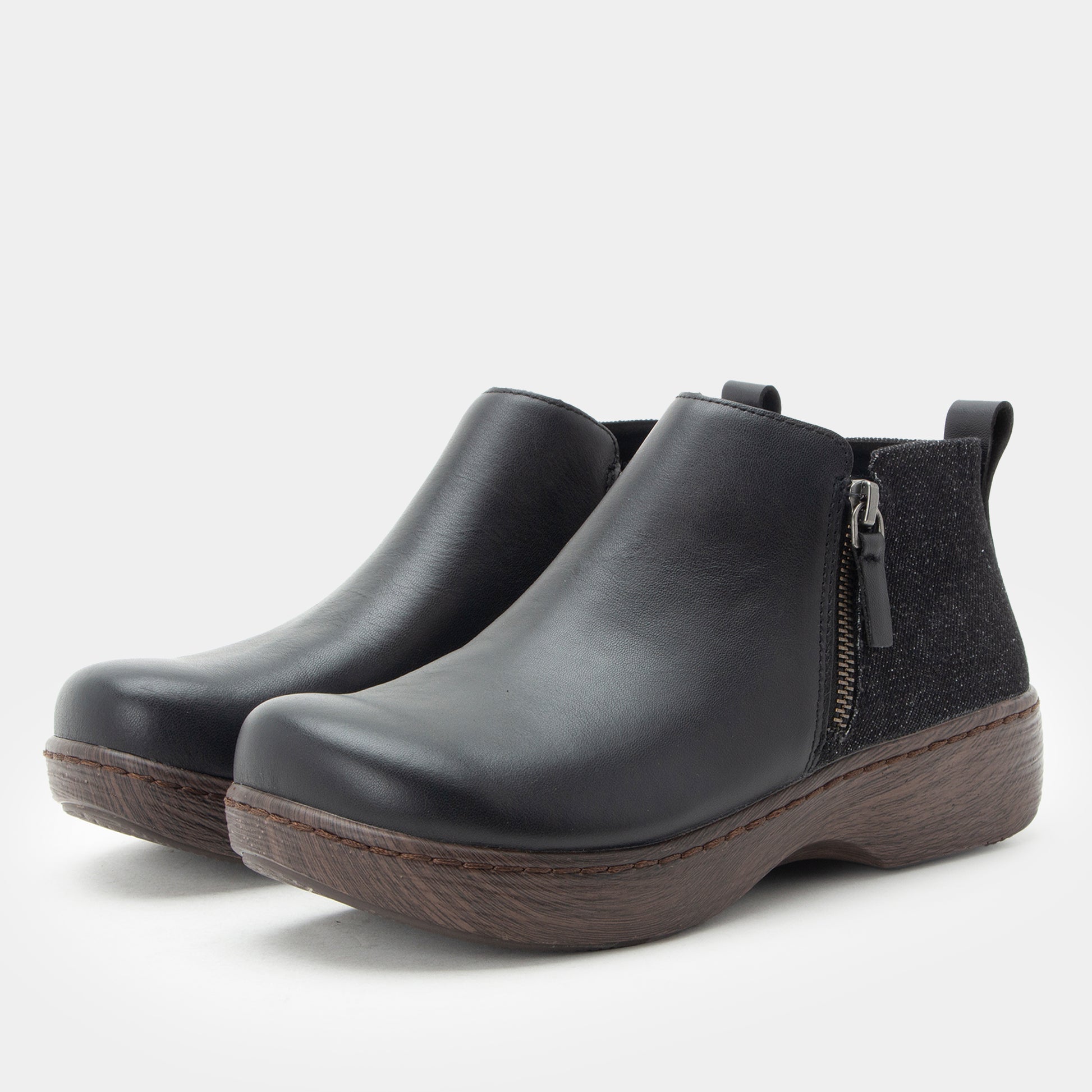 Pair of black ankle boots with a zipper on a white background