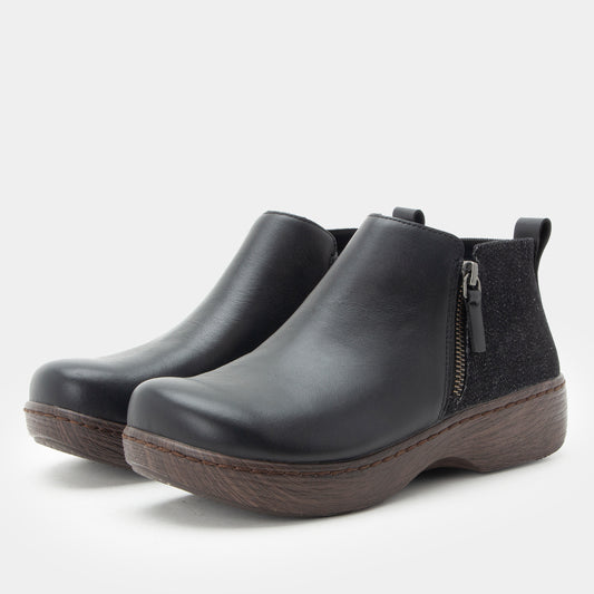 Pair of black ankle boots with a zipper on a white background