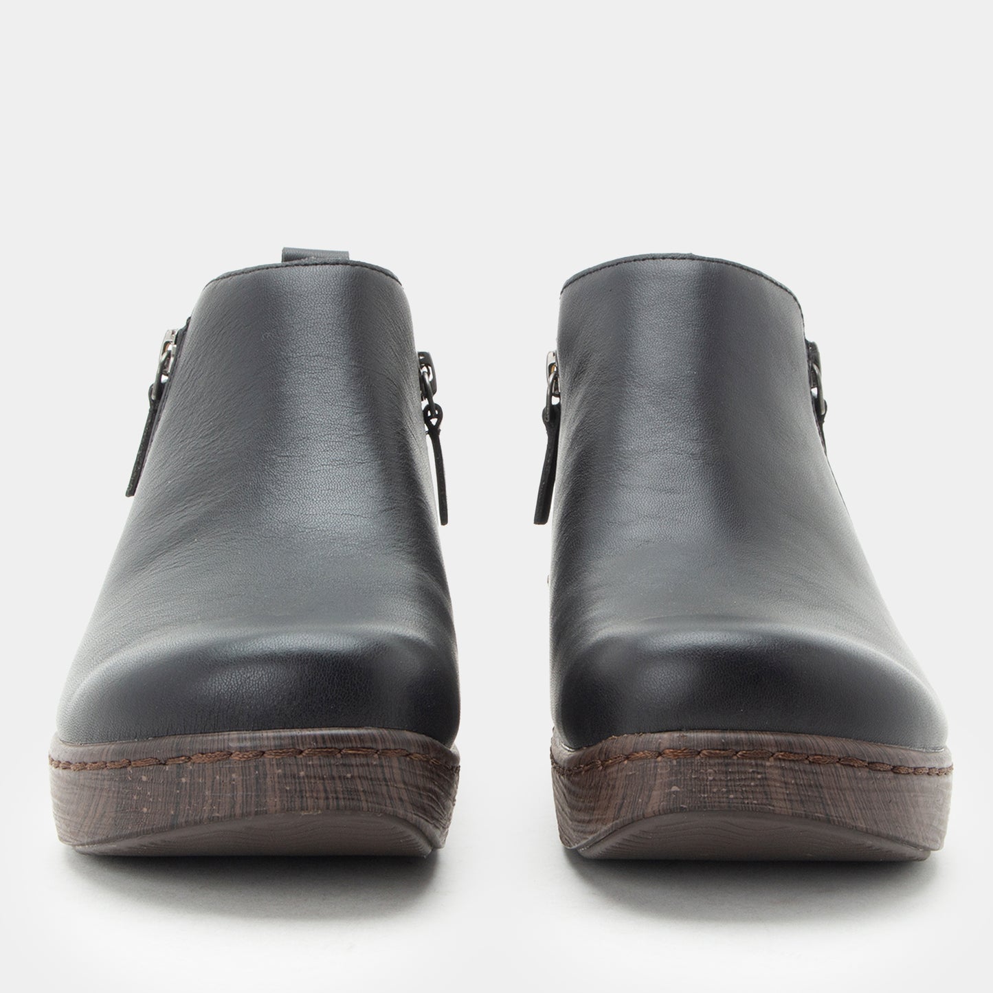 Pair of black leather clogs on a white background