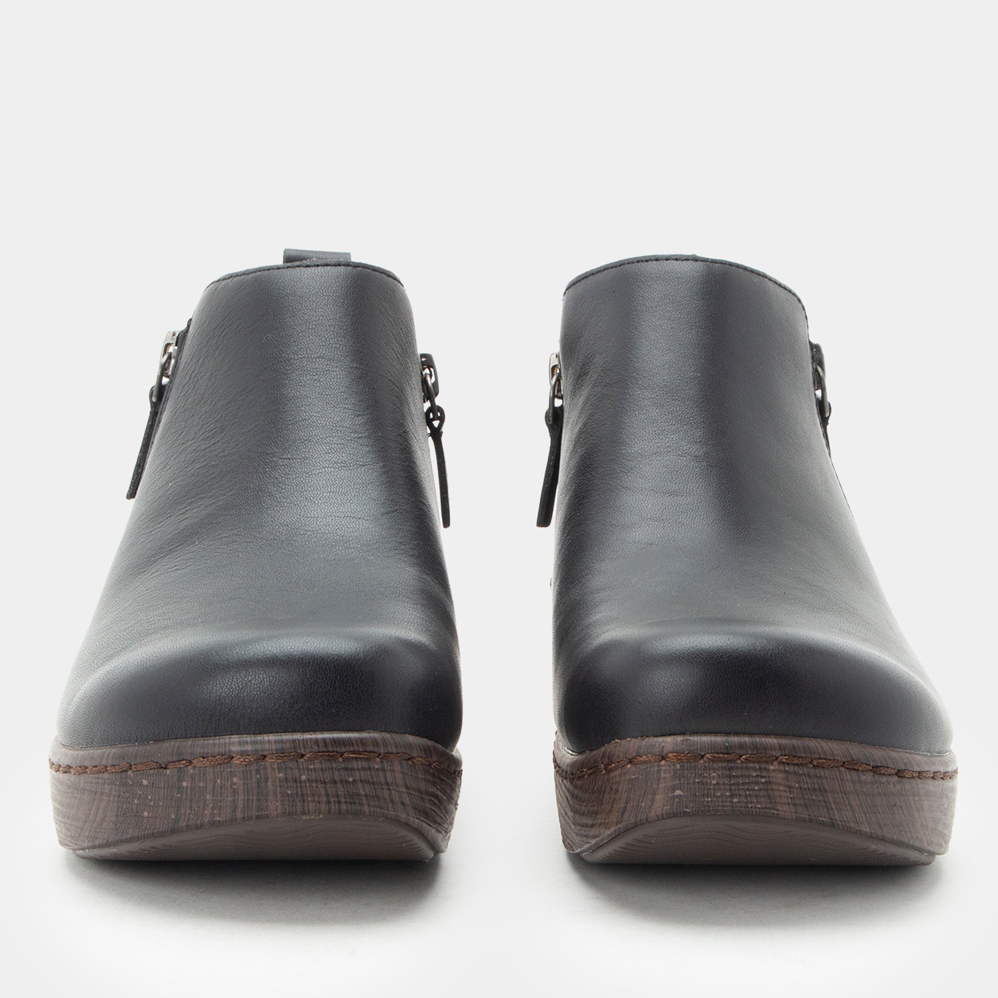 Pair of black leather clogs on a white background