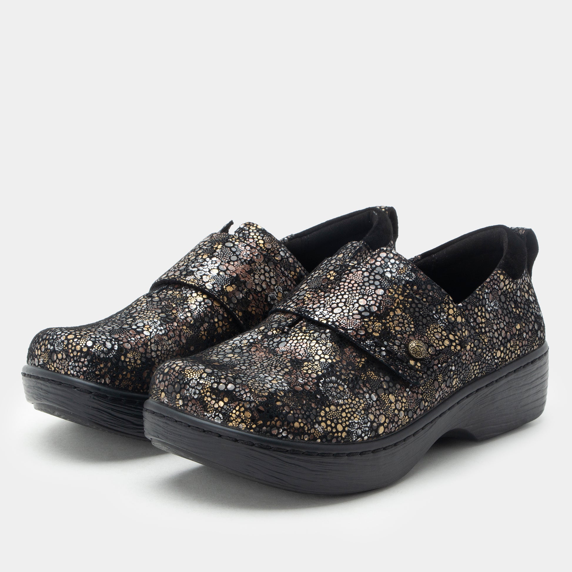 Pair of glittery shoes with black soles on a white background