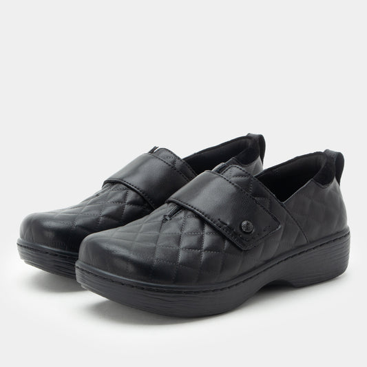Pair of black quilted shoes on a white background