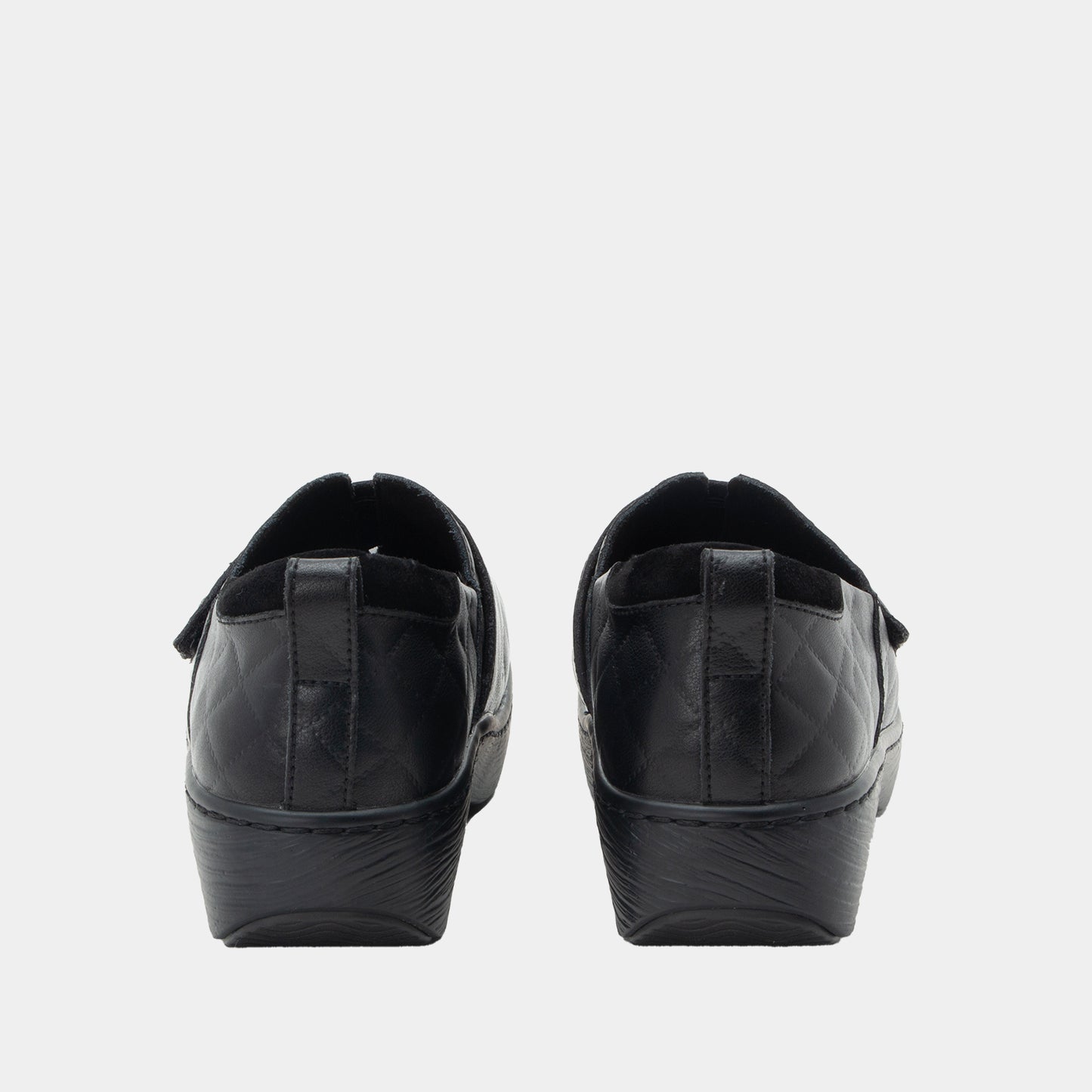 Black slip-on shoes on a light gray background