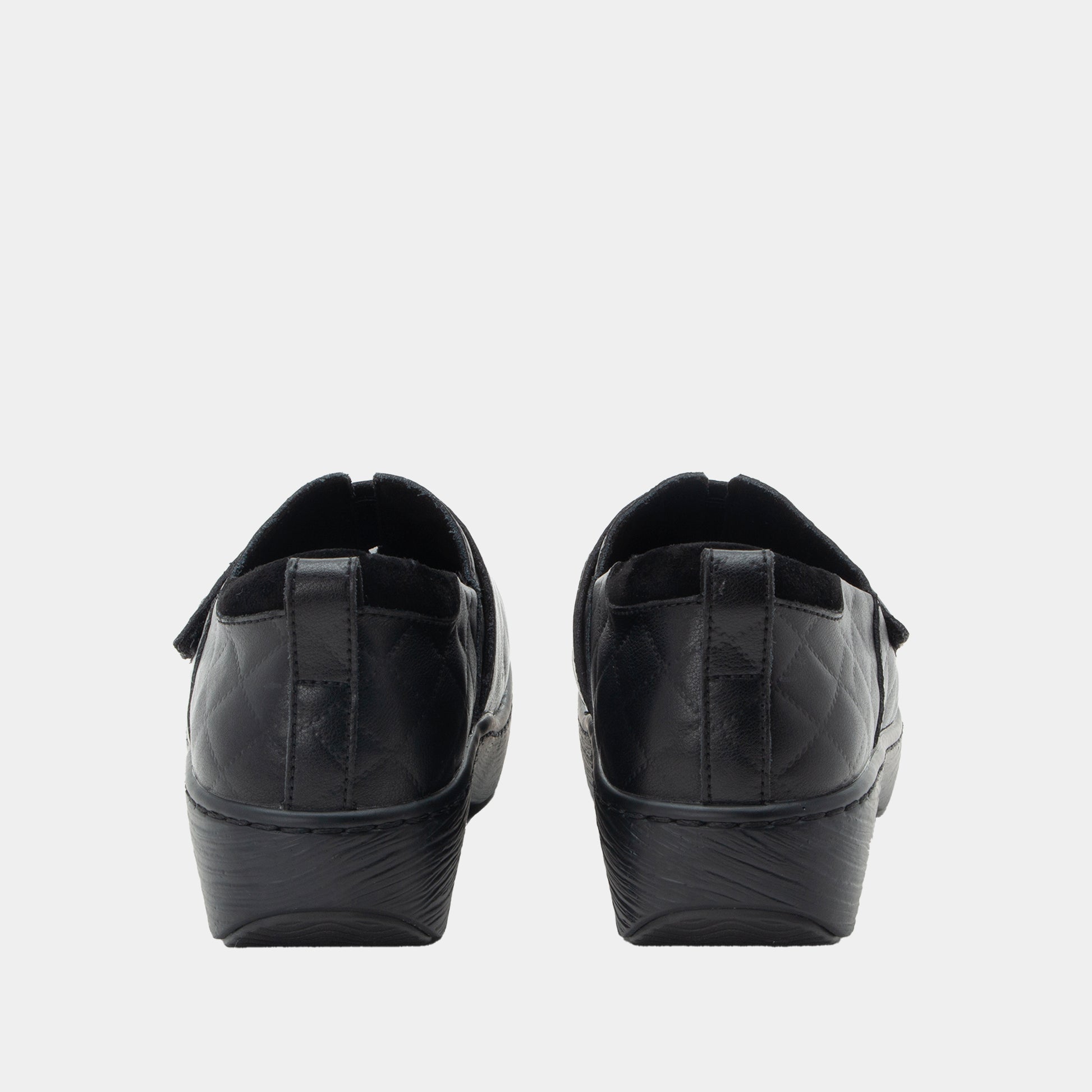Black slip-on shoes on a light gray background