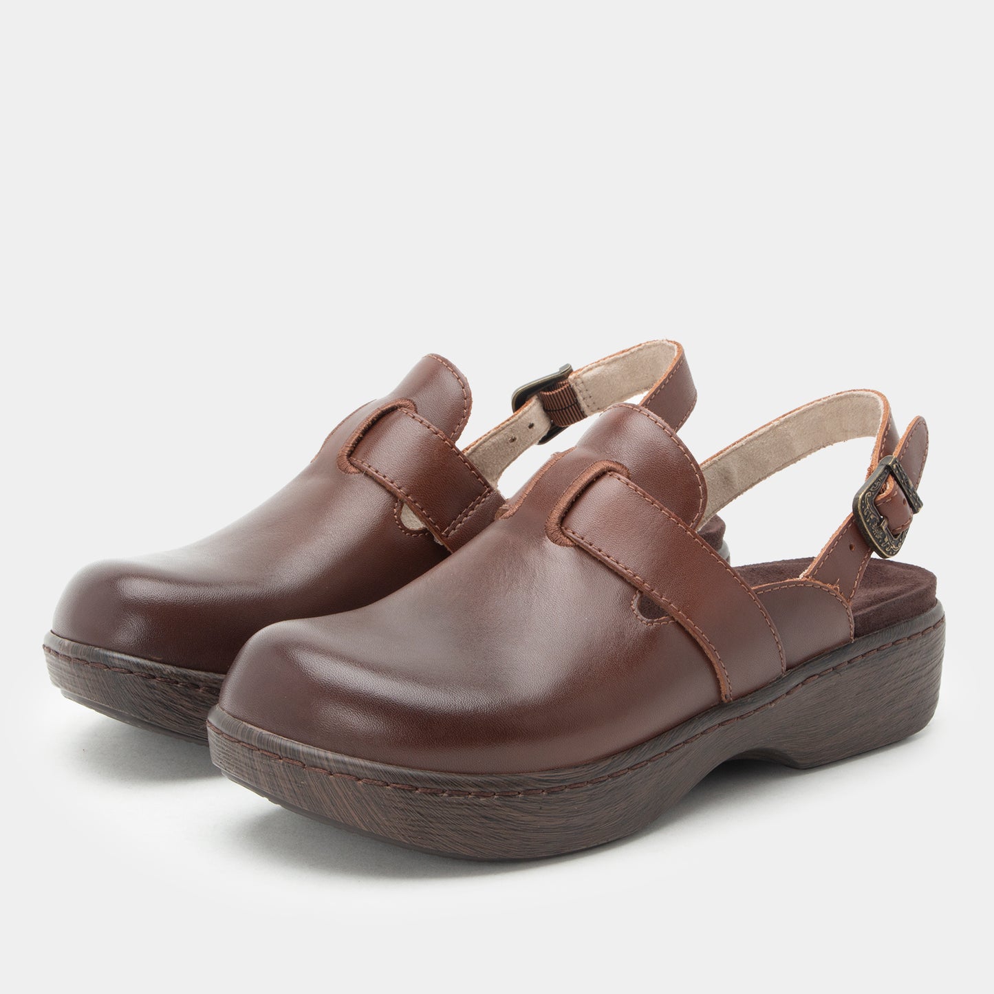 A pair of dark brown leather clogs with adjustable ankle straps and dark brown soles, photographed on a light gray background.