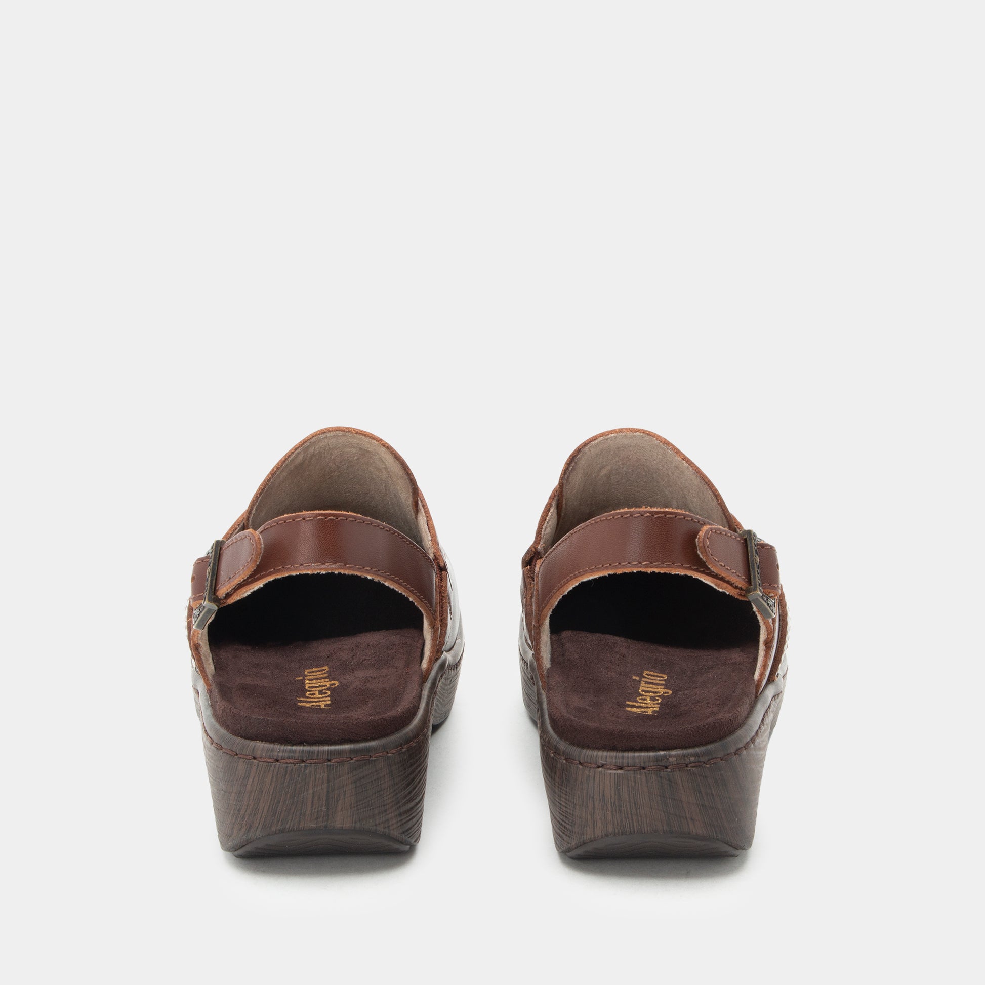 A pair of women's wedge sandals shown from the back, featuring dark brown leather straps and textured dark brown wedge heels, set against a light gray background.
