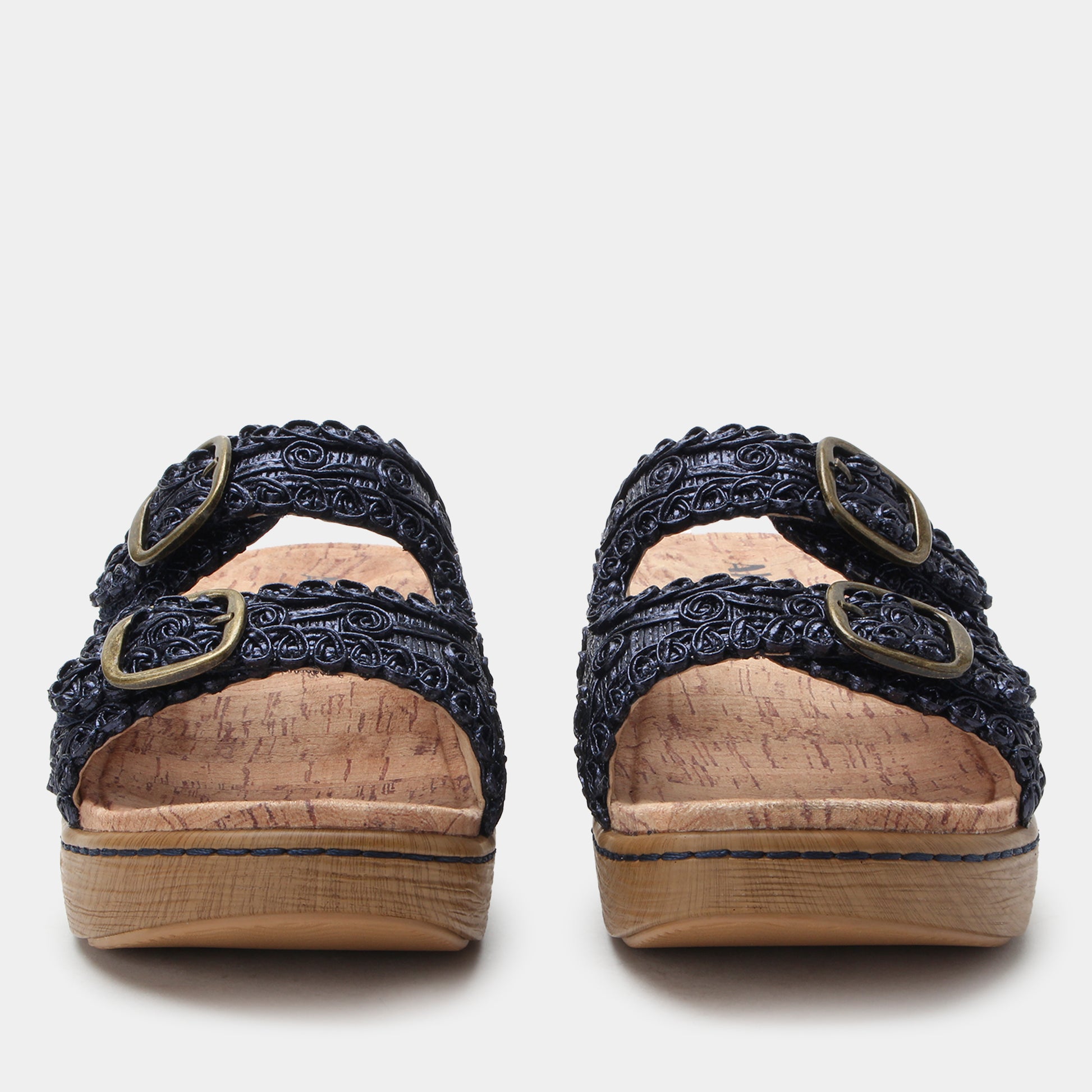 Pair of black sandals with decorative straps on a white background