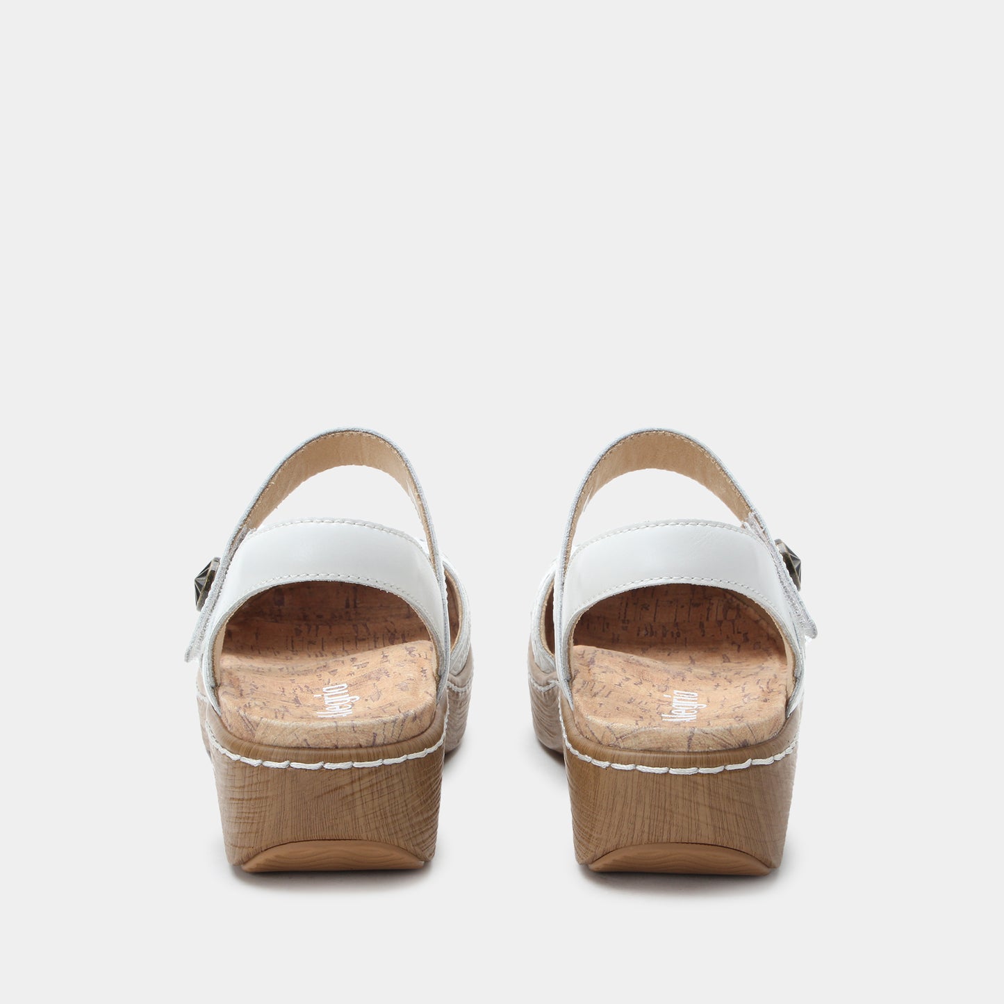 Pair of white sandals with cork platforms on a light gray background