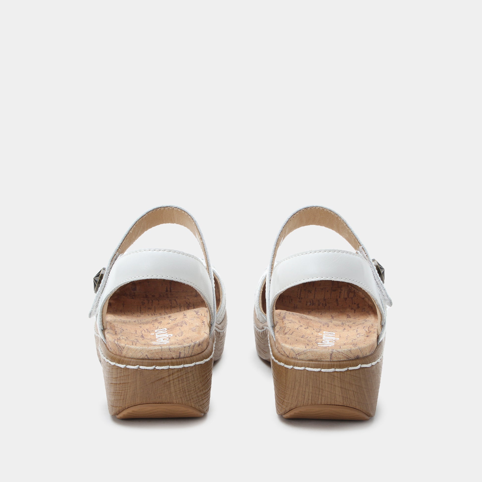 Pair of white sandals with cork platforms on a light gray background