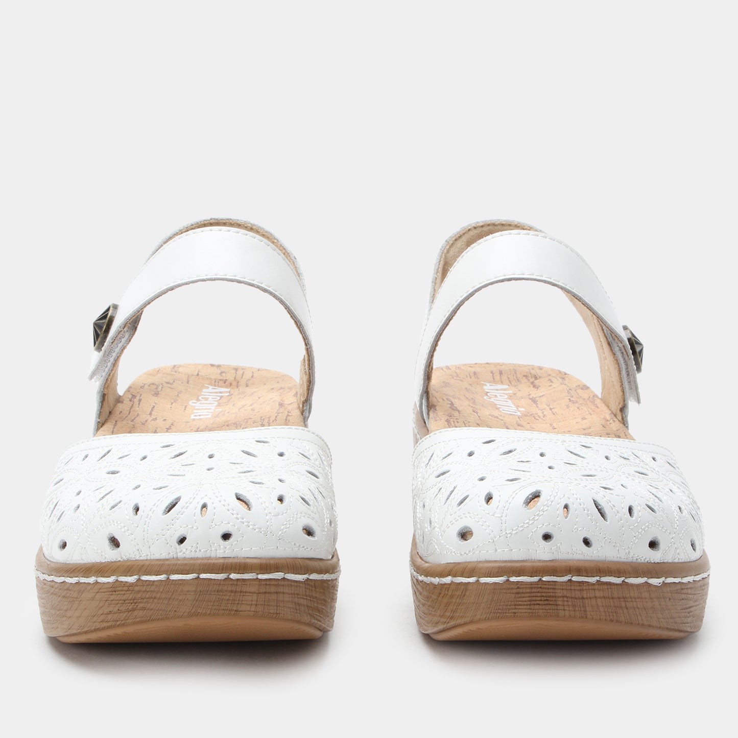 White sandals with brown soles on a light gray background