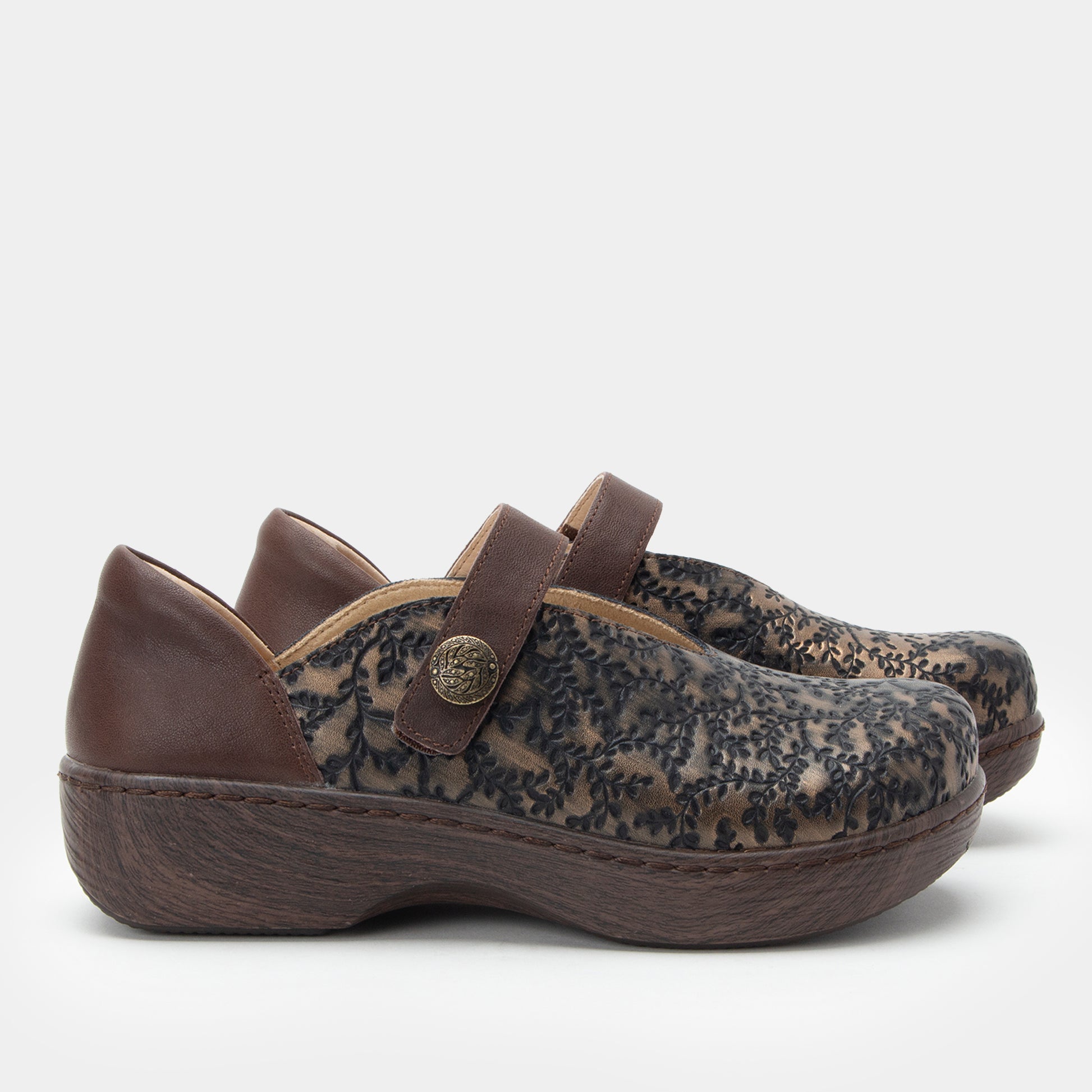 Pair of brown clogs with floral pattern on a white background