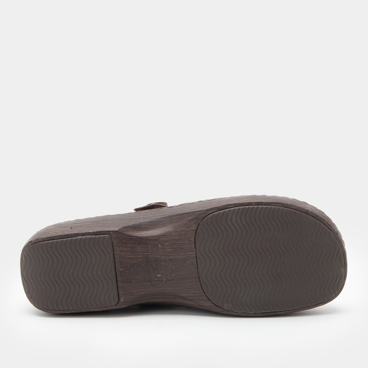 Brown sandal with textured sole on a white background
