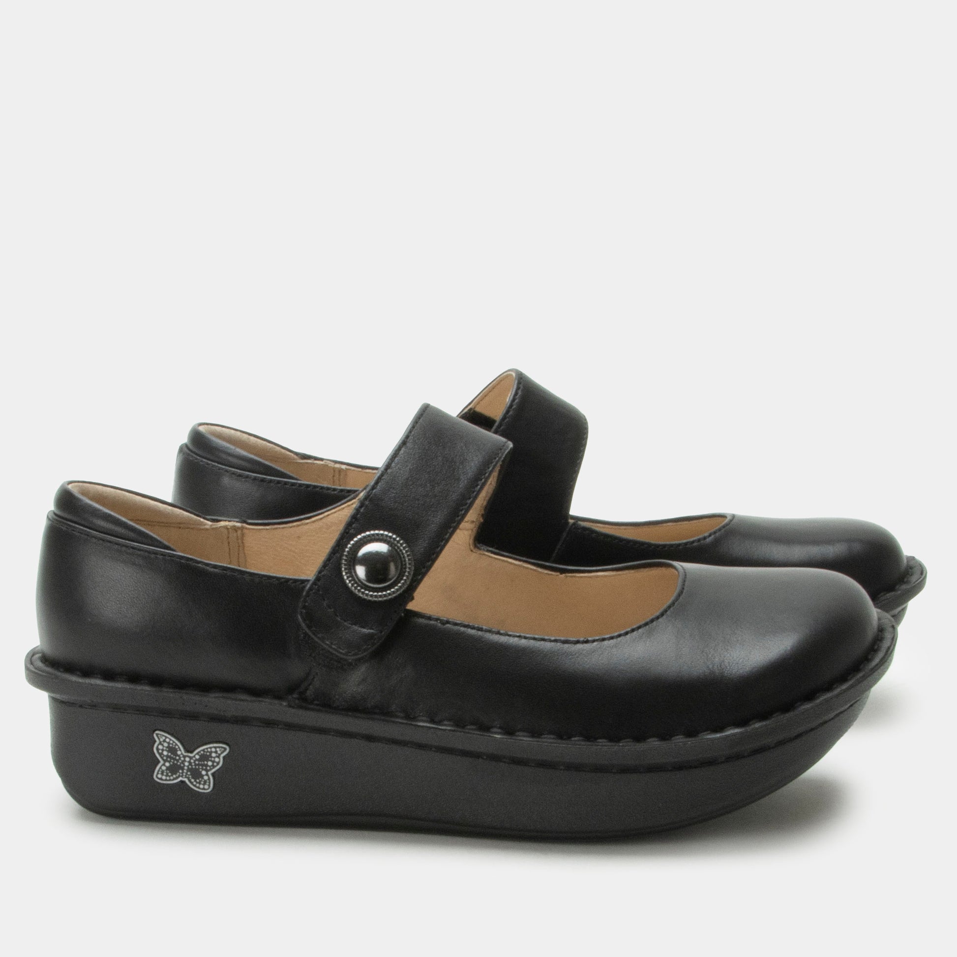 Pair of black leather shoes with a strap and button on a white background