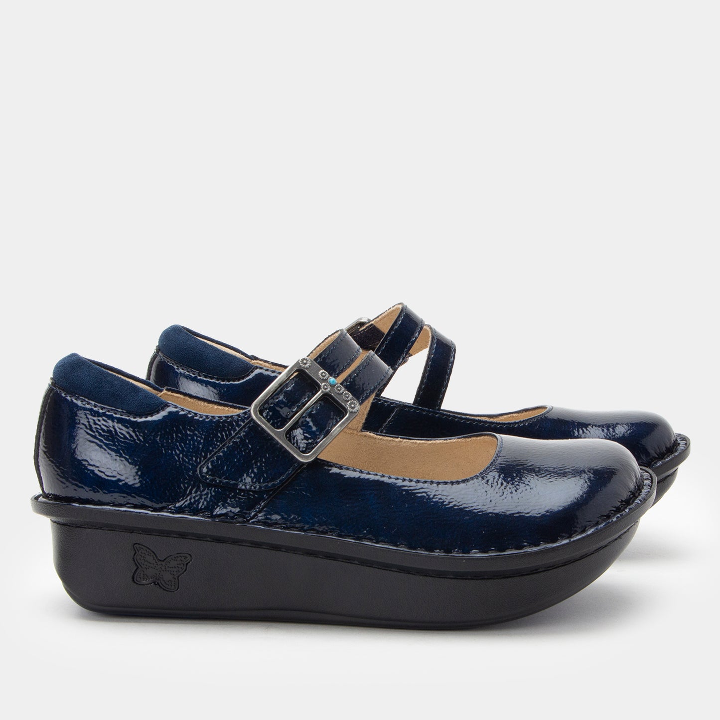 Navy blue shoes with a strap and buckle on a light gray background