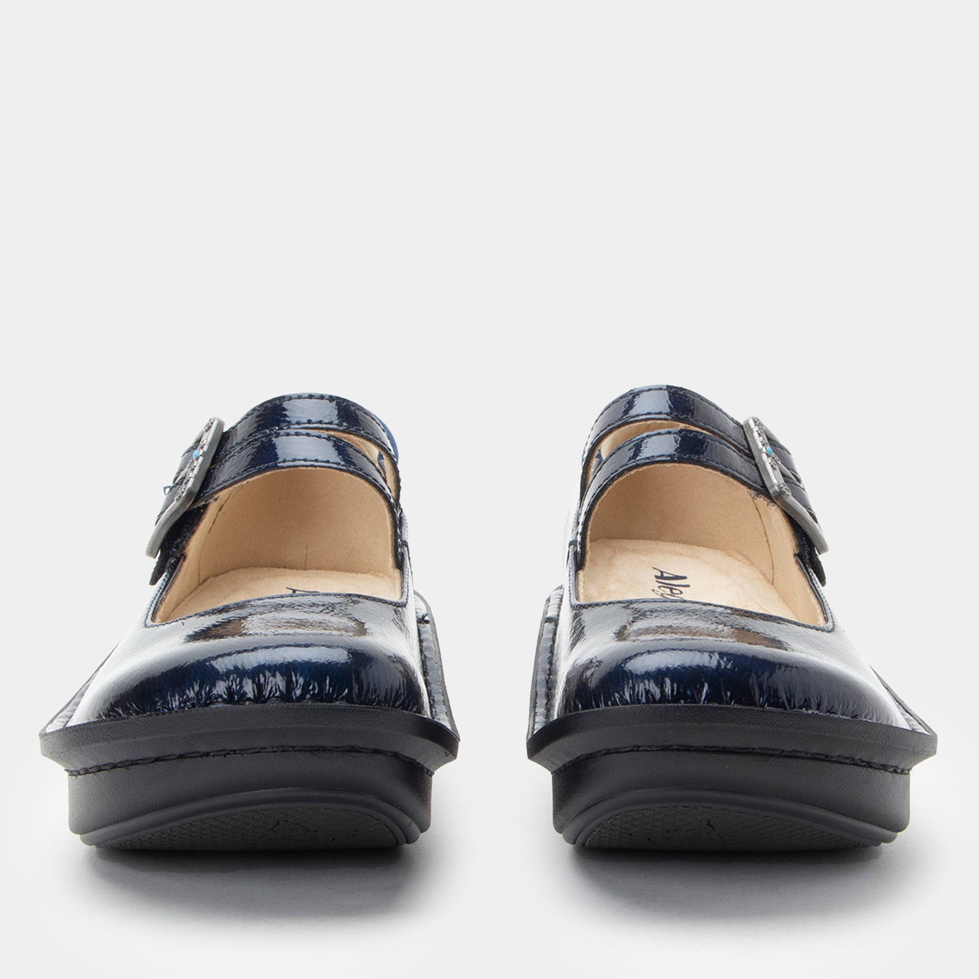 Pair of navy blue shoes with buckles on a white background