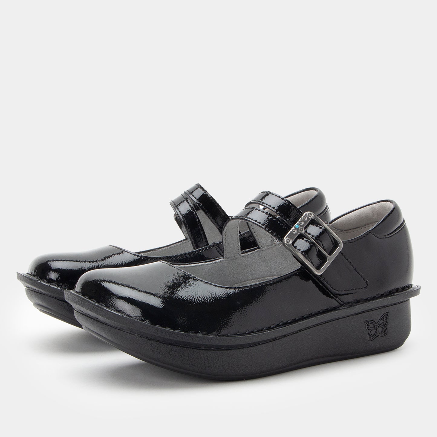 Black patent leather shoes with buckles on a white background