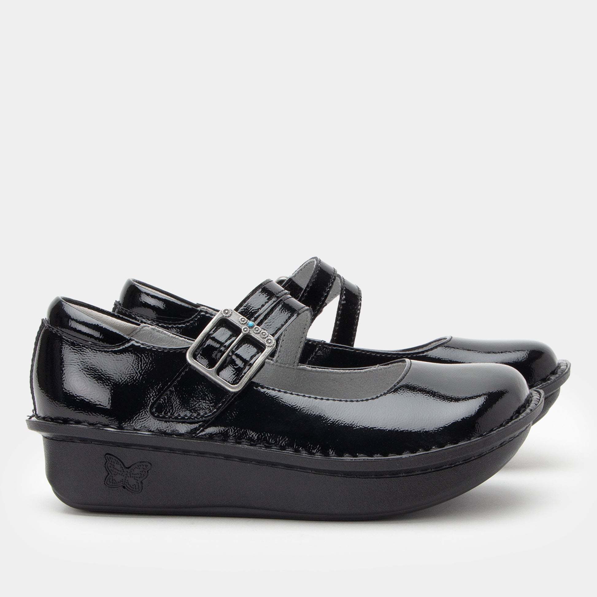 Black patent leather shoes with a buckle on a white background