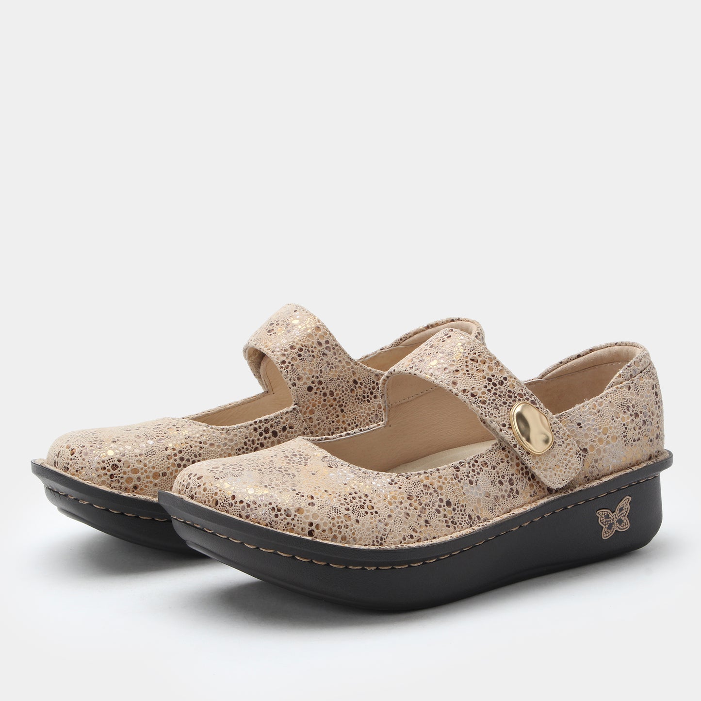 Pair of speckled patterned shoes with a strap on a white background