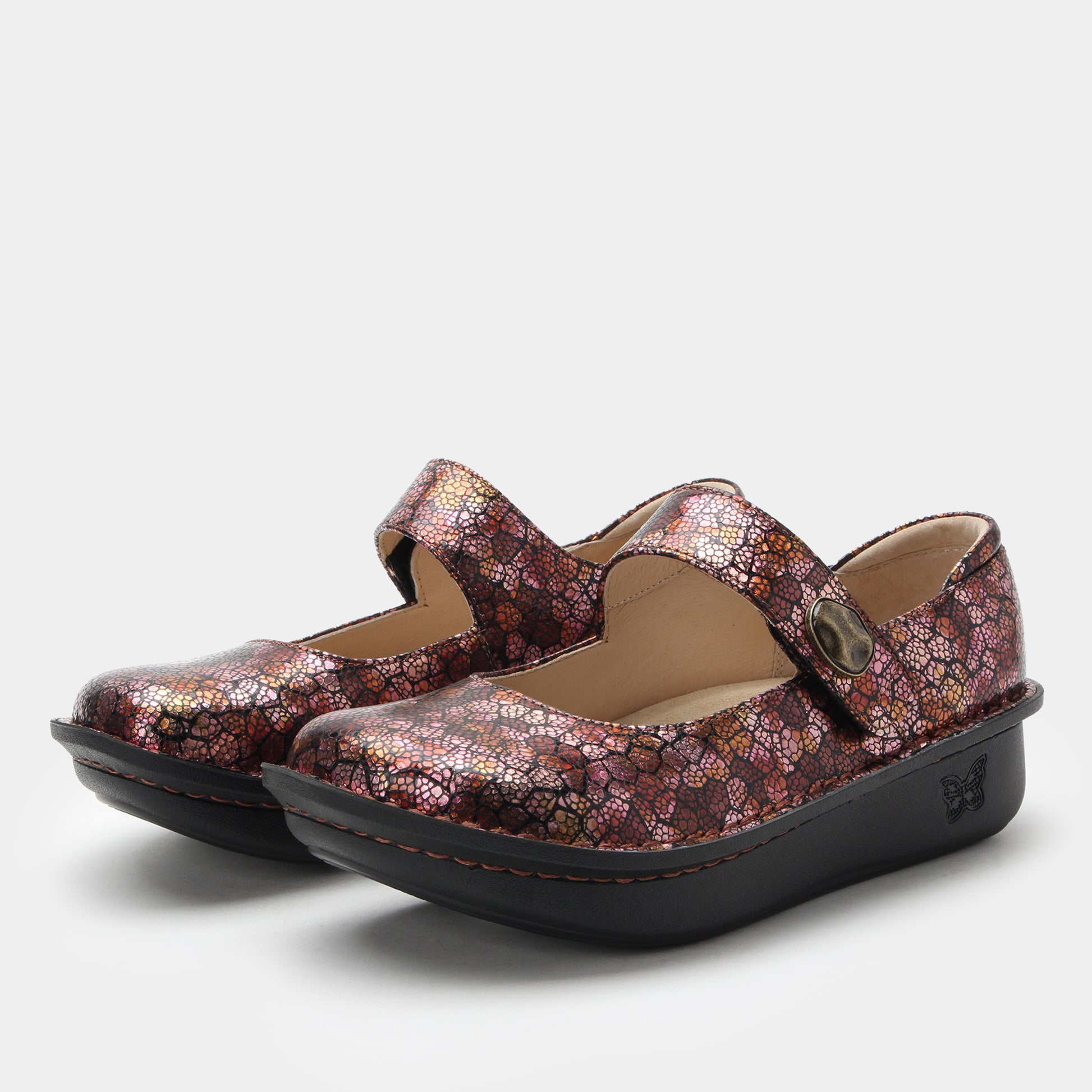Pair of floral-patterned shoes with black soles on a light gray background