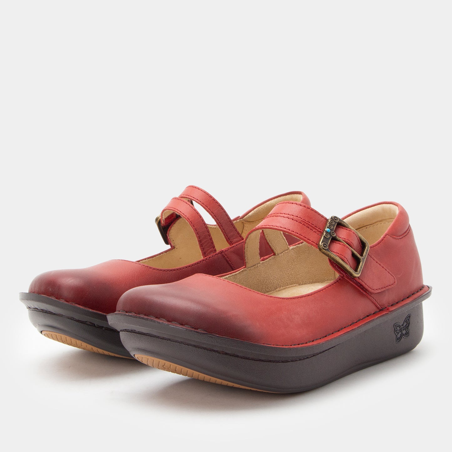 Pair of red shoes with a strap and black sole on a white background