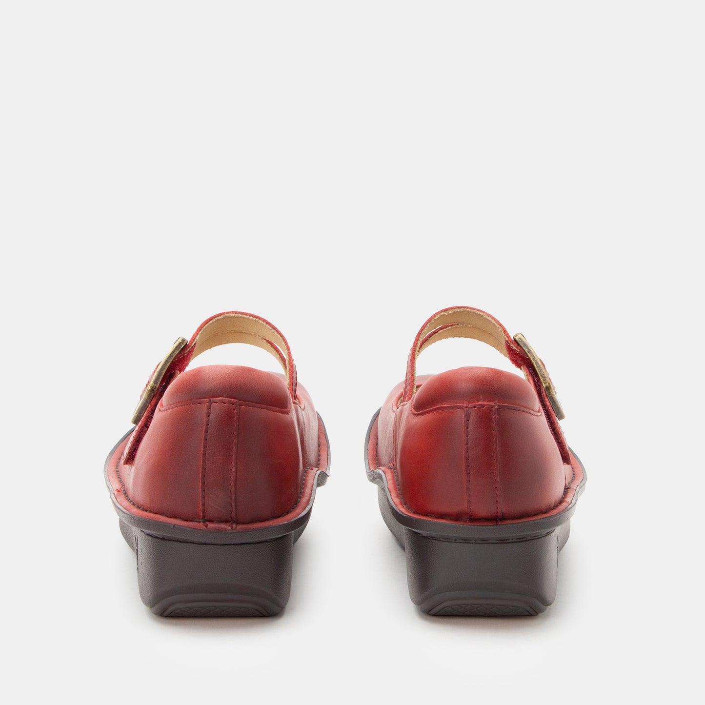 Pair of red shoes with black soles on a white background