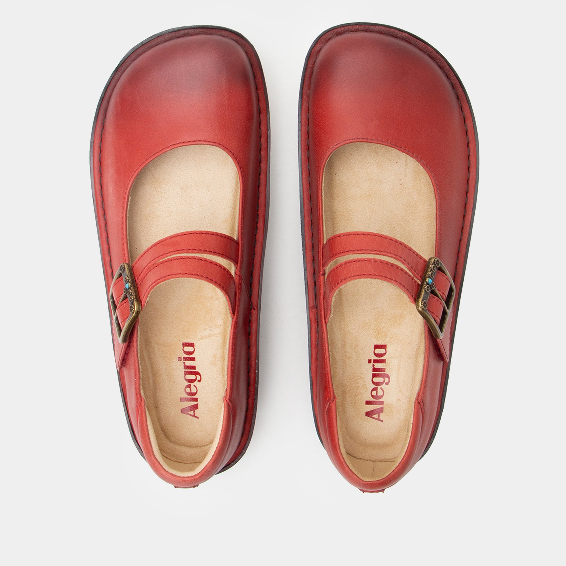 Red shoes with 'Alegria' branding on a white background